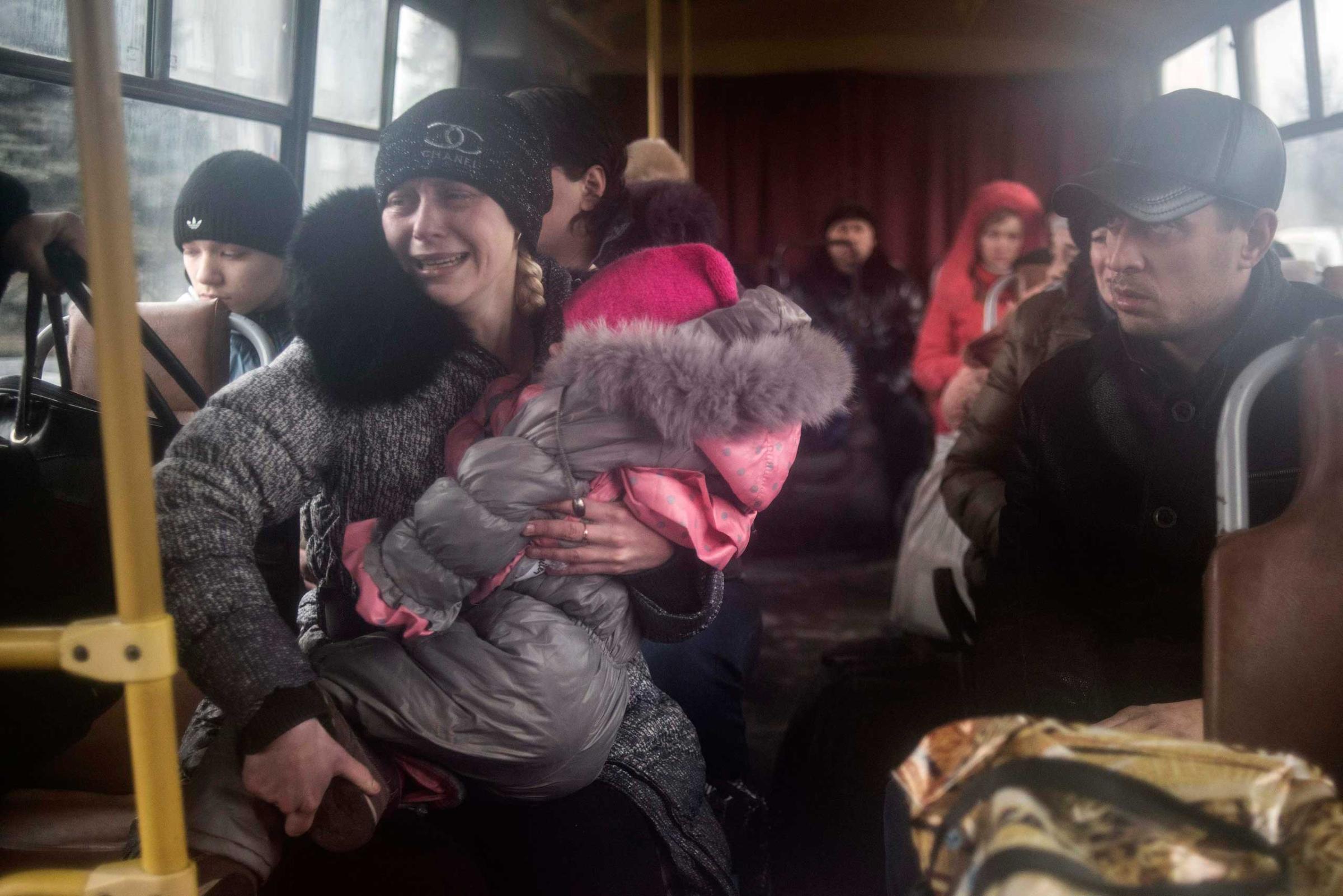 People sit inside a bus before the departure, as they flee due to the military conflict, in Debaltseve
