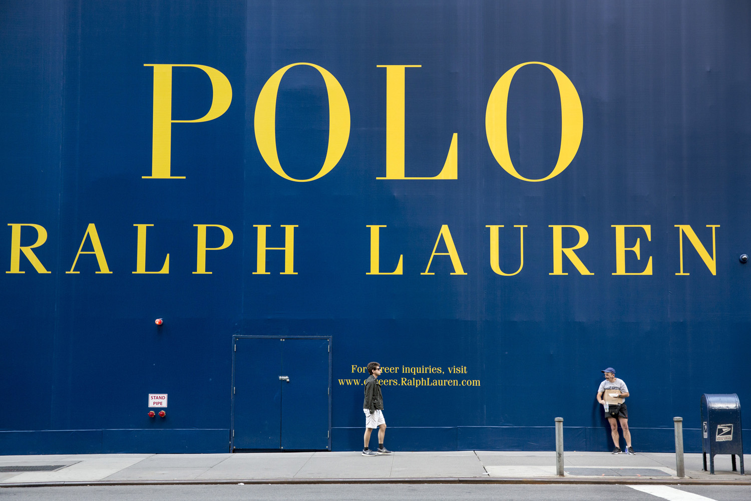A man begs for money next to a construction site of a new Ralph Lauren flagship store on Fifth Avenue, New York, June 21, 2014.