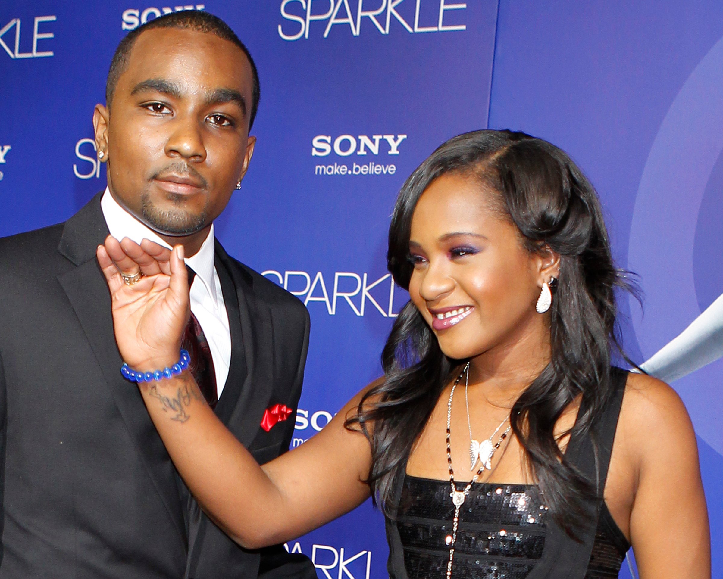 Bobbi Kristina Brown reveals a tattoo with the initials "W H" as she waves while arriving with boyfriend Nick Gordon at the premiere of the new film "Sparkle" starring Jordin Sparks and the late Whitney Houston in Hollywood