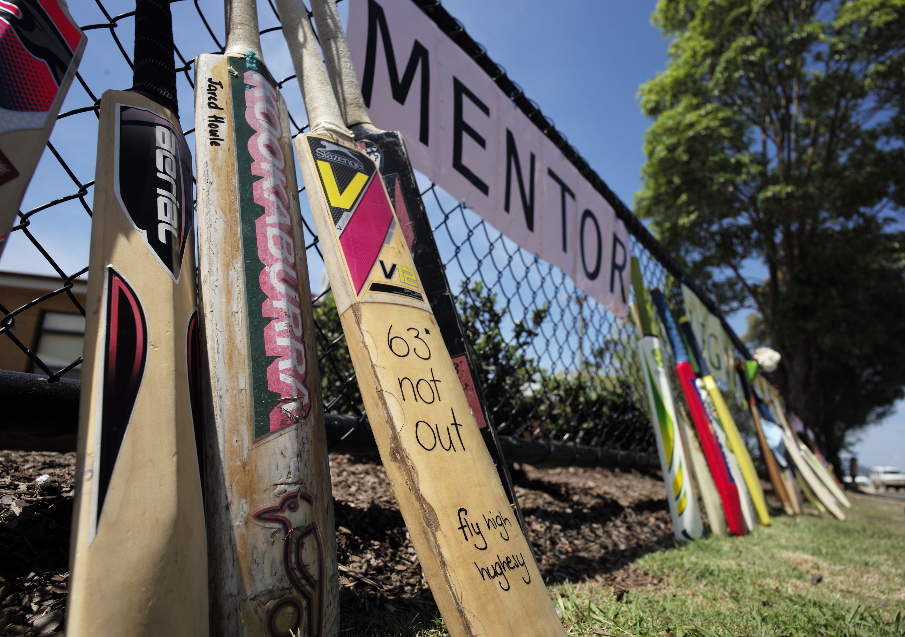Cricket bats line the funeral procession route for Australian cricketer Phillip Hughes outside a primary school in his home town of Macksville, Dec. 3, 2014 (Jason Reed—Reuters)