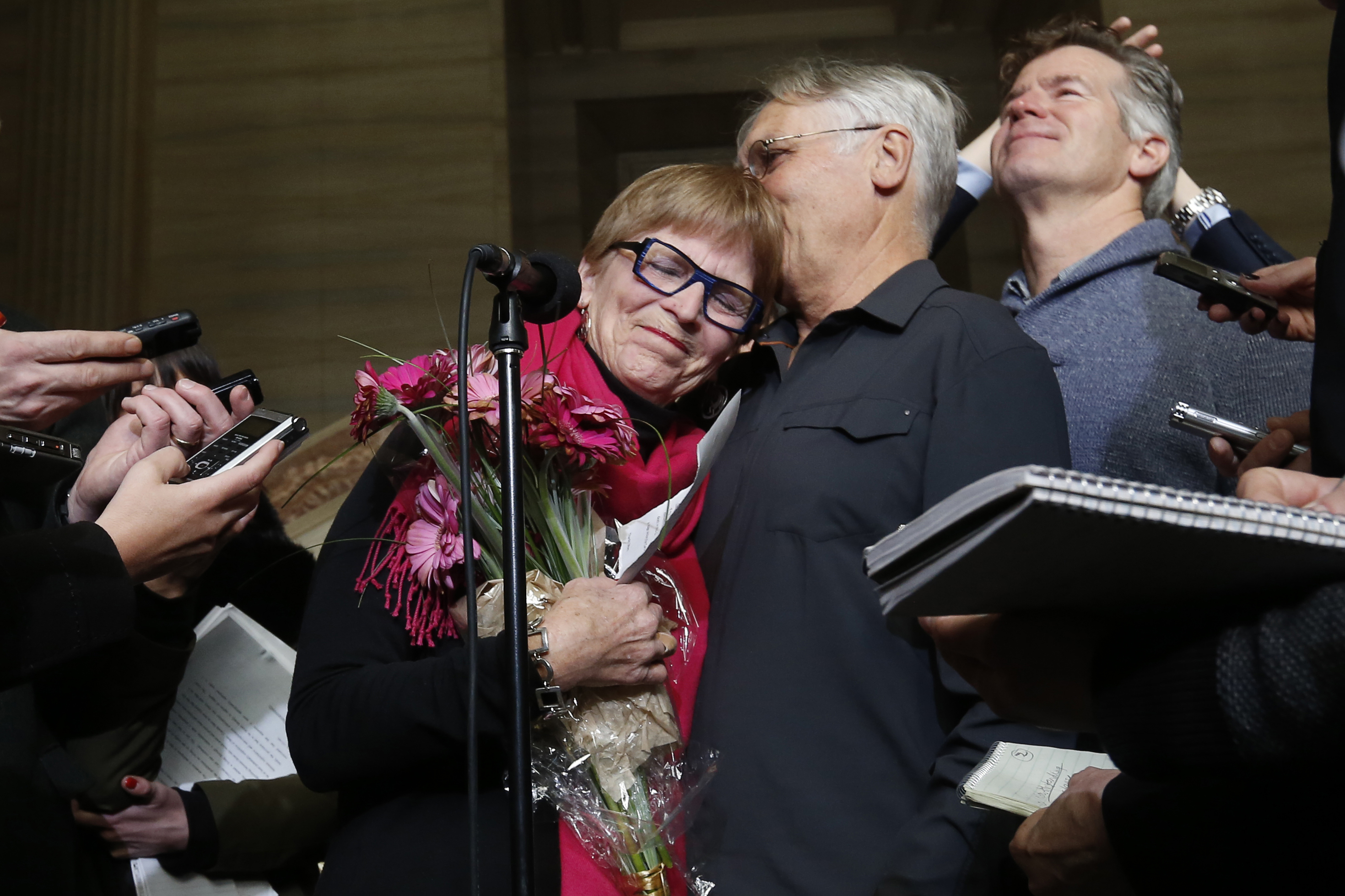 Lee Carter embraces her husband Hollis Johnson  while speaking to journalists at the Supreme Court of Canada in Ottawa on Feb. 6, 2015.