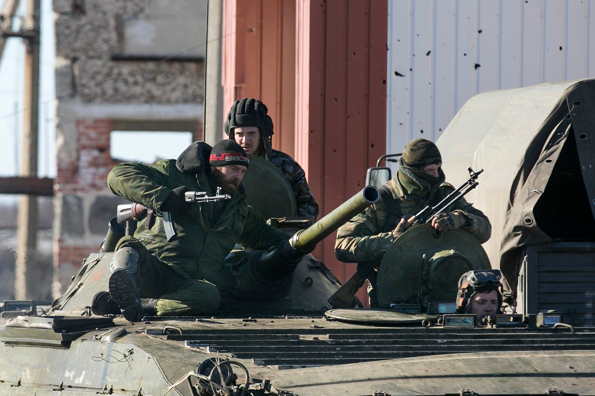 Fighters with separatist self-proclaimed Donetsk People's Republic army sit on top of a moving armoured personnel carrier heading to the front line in the village of Nikishine, south east of Debaltseve Feb.17, 2015.