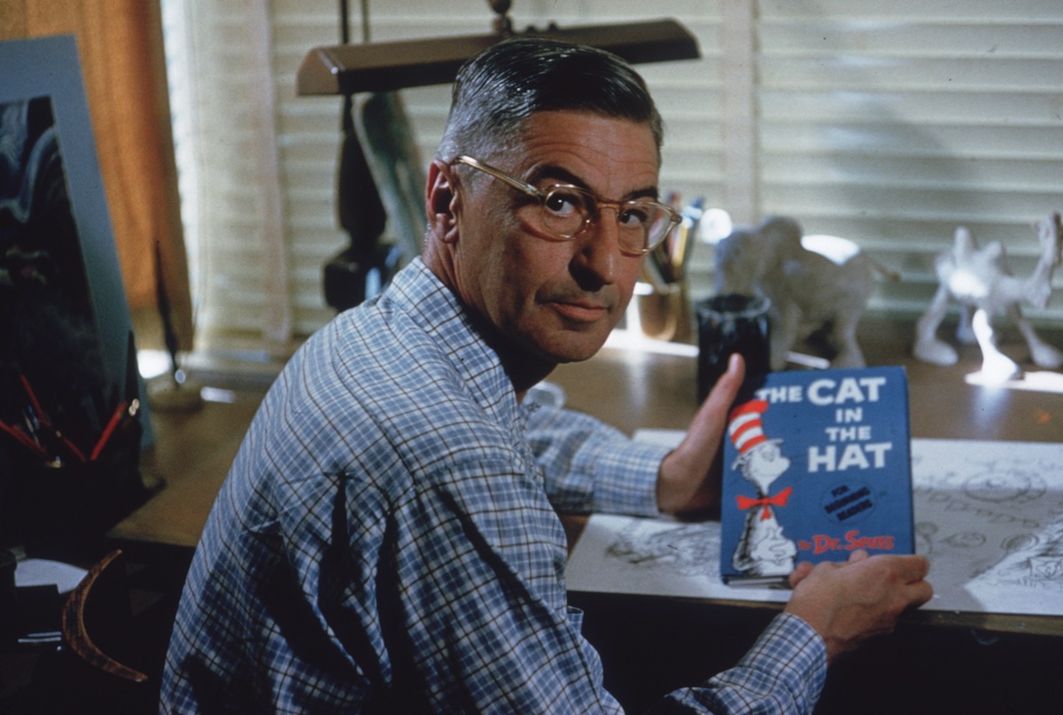 Dr Seuss sits at his drafting table in his home office with a copy of his book, 'The Cat in the Hat', La Jolla, Calif., Apr. 25, 1957. (Gene Lester—Getty Images)