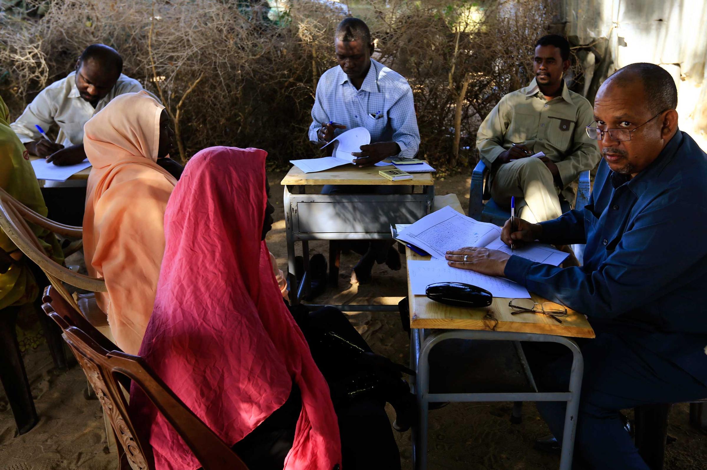 Special Prosecutor for Crimes in Darfur Yasir Ahmed Mohamed and his team talk to women during an investigation into allegations of mass rape in the village of Tabit, in North Darfur, Nov. 20, 2014.