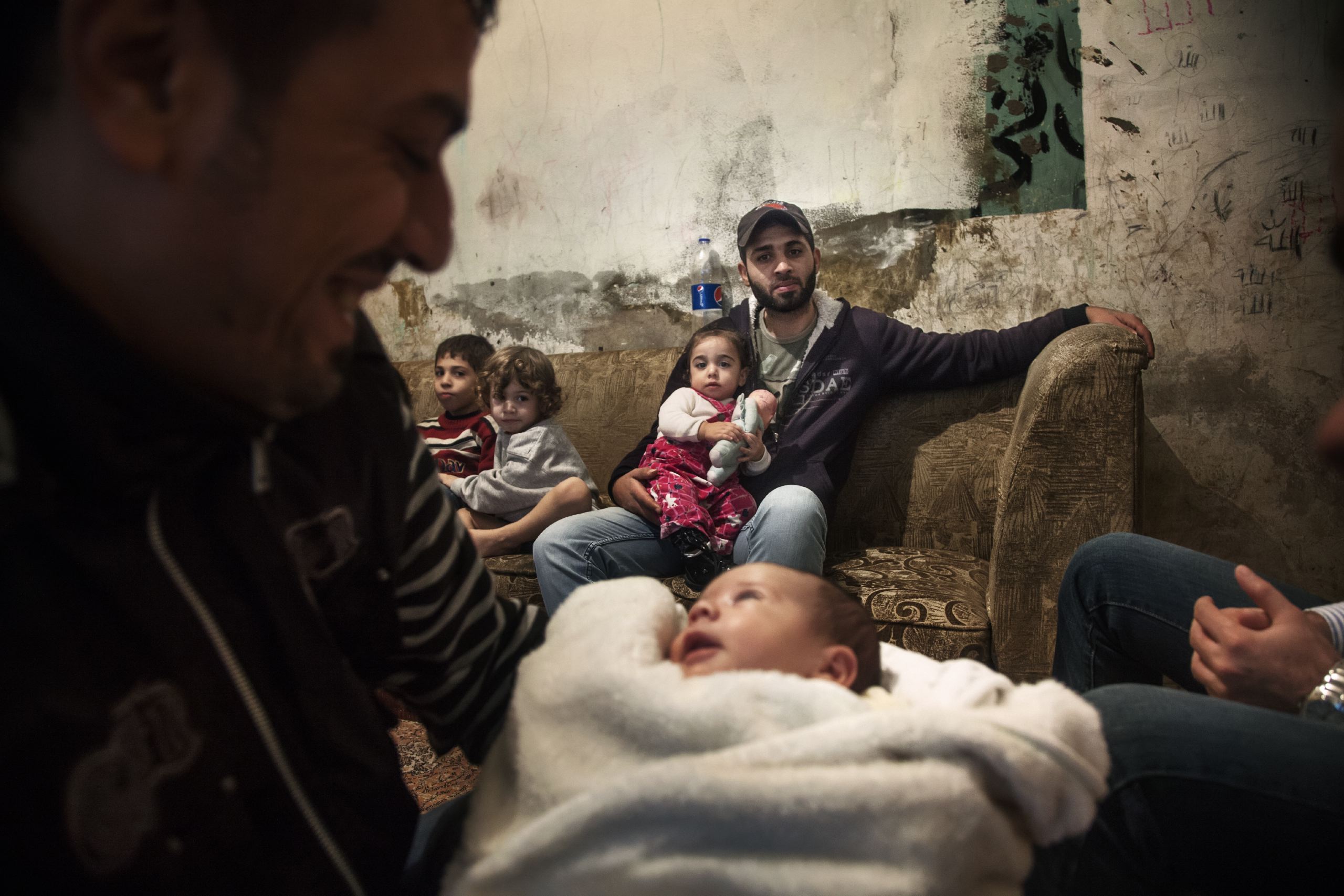 Ahmad, 33, shows his friend's baby in sunni neighborhood of Bab al-Tabbaneh in Tripoli, Lebanon, Nov. and Dec. 2014.