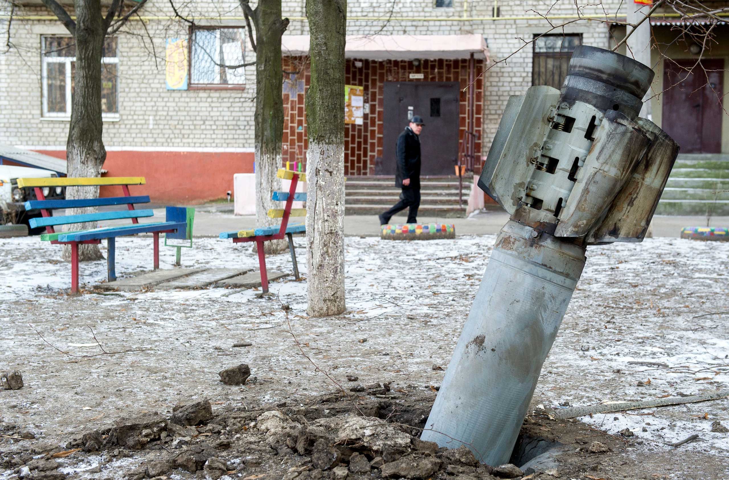 A man walks past an unexploded rocket in Kramatorsk, eastern Ukraine on Feb. 11, 2015. (Volomydyr Shuvayev—AFP/Getty Images)