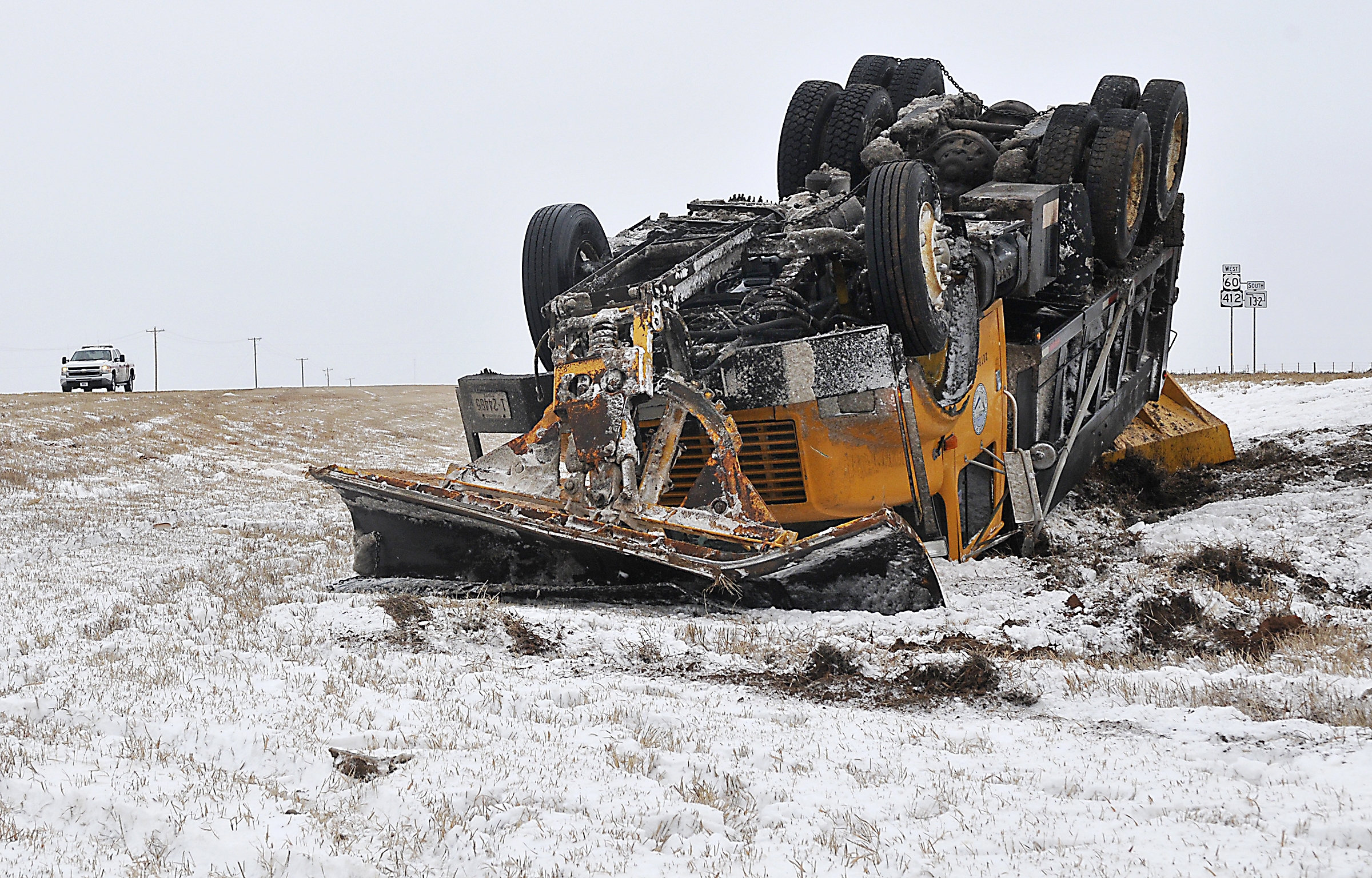 An Oklahoma Department of Transportation sand truck rest on it's top in the median of US 412 west of Enid, Okla. Sunday, after it was involved in an accident with another vehicle on Feb. 22, 2015 (Billy Hefton—AP)