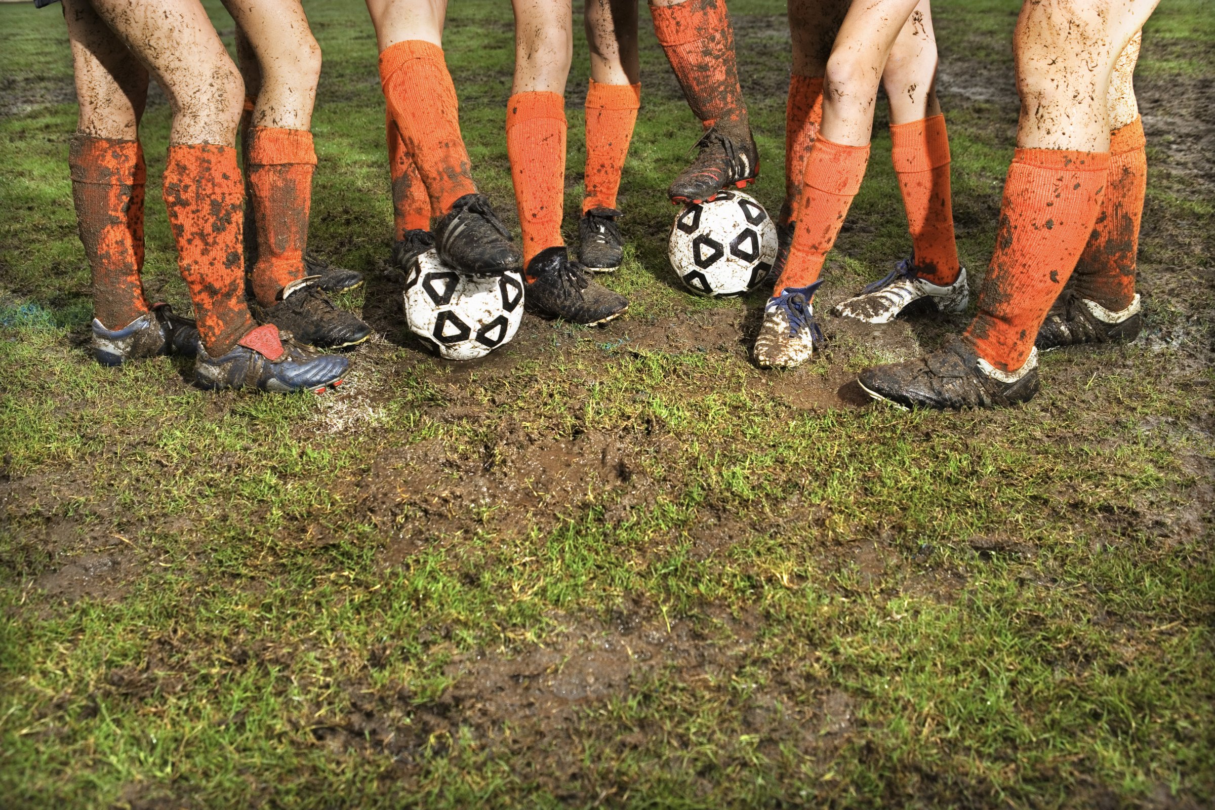 Muddy legs of soccer players