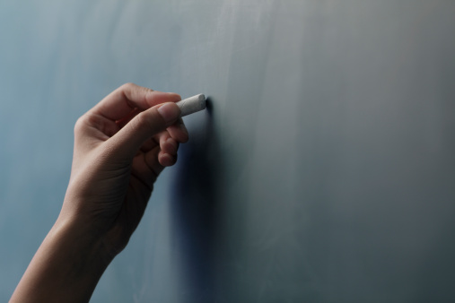 hand-holding-chalk-chalkboard