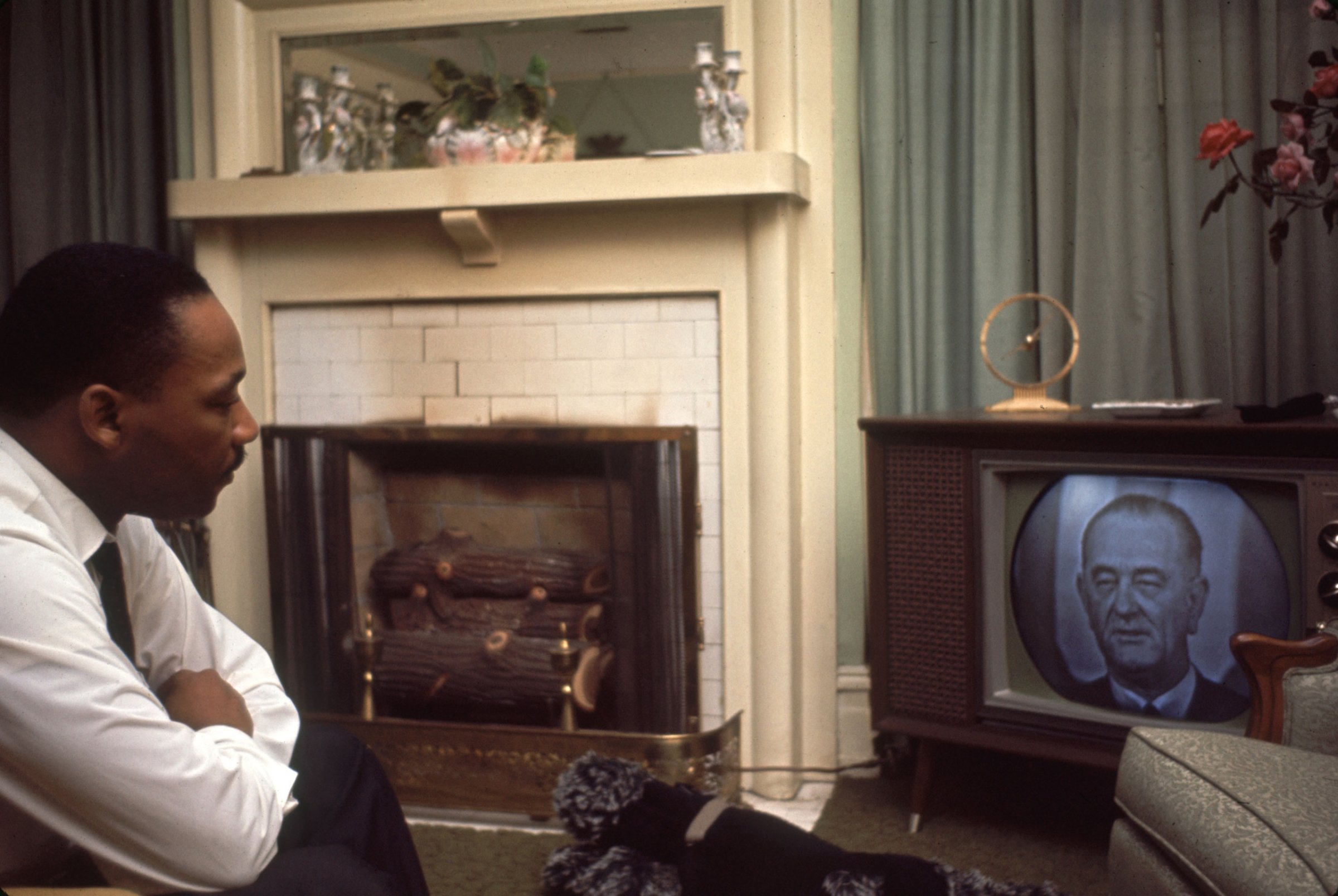 American religious and Civil Rights leader Martin Luther King Jr. watches US President Lyndon Johnson on television, Selma, Alabama, March 1965.