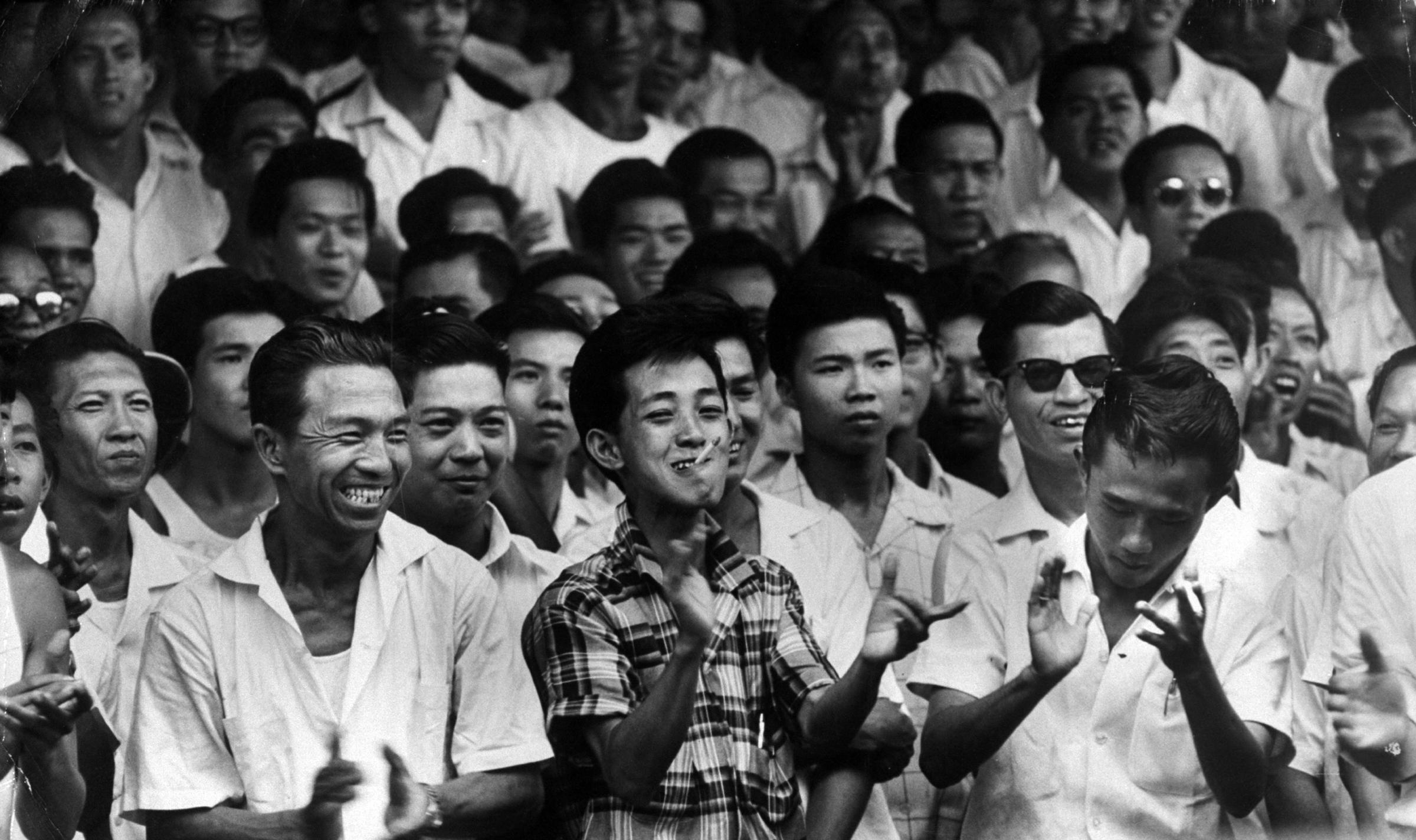 Crowds cheering at election results, Singapore, 1959.