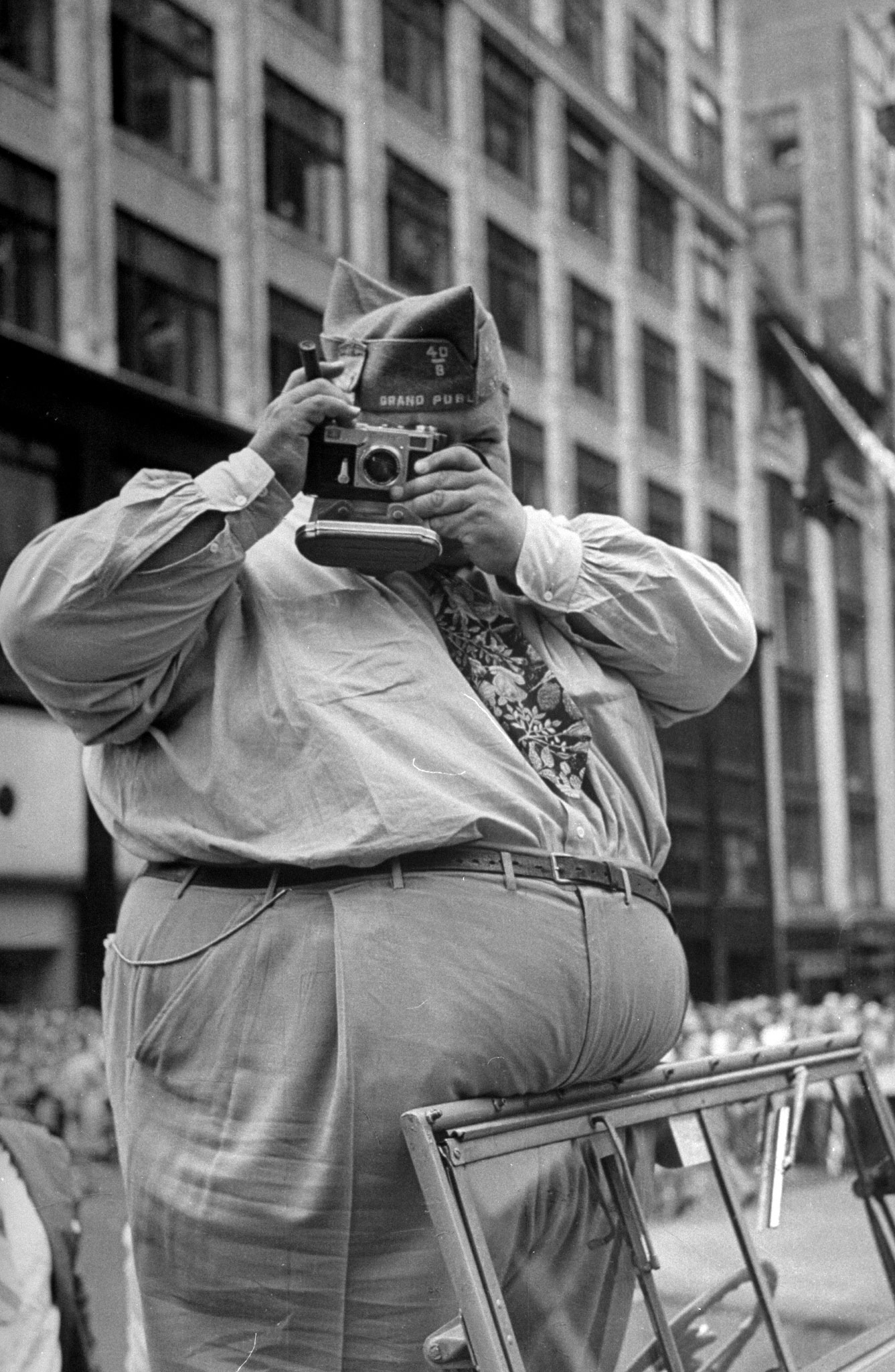 A large man taking photos while standing