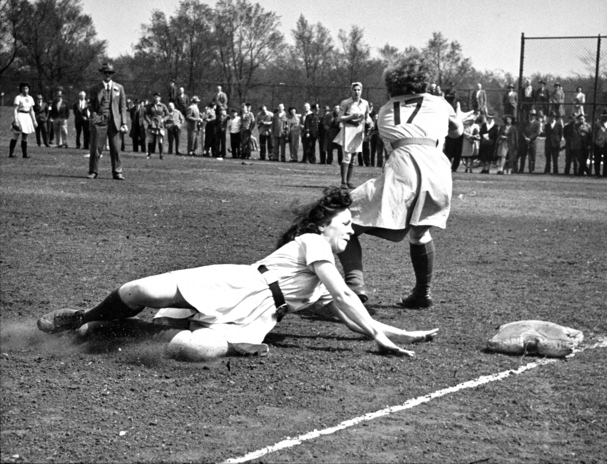 Penny O'Brian, Fort Wayne rookie infielder slides into third base. Sliding and bare legs are incompatible but girls do it regularly in their enthusiasm.