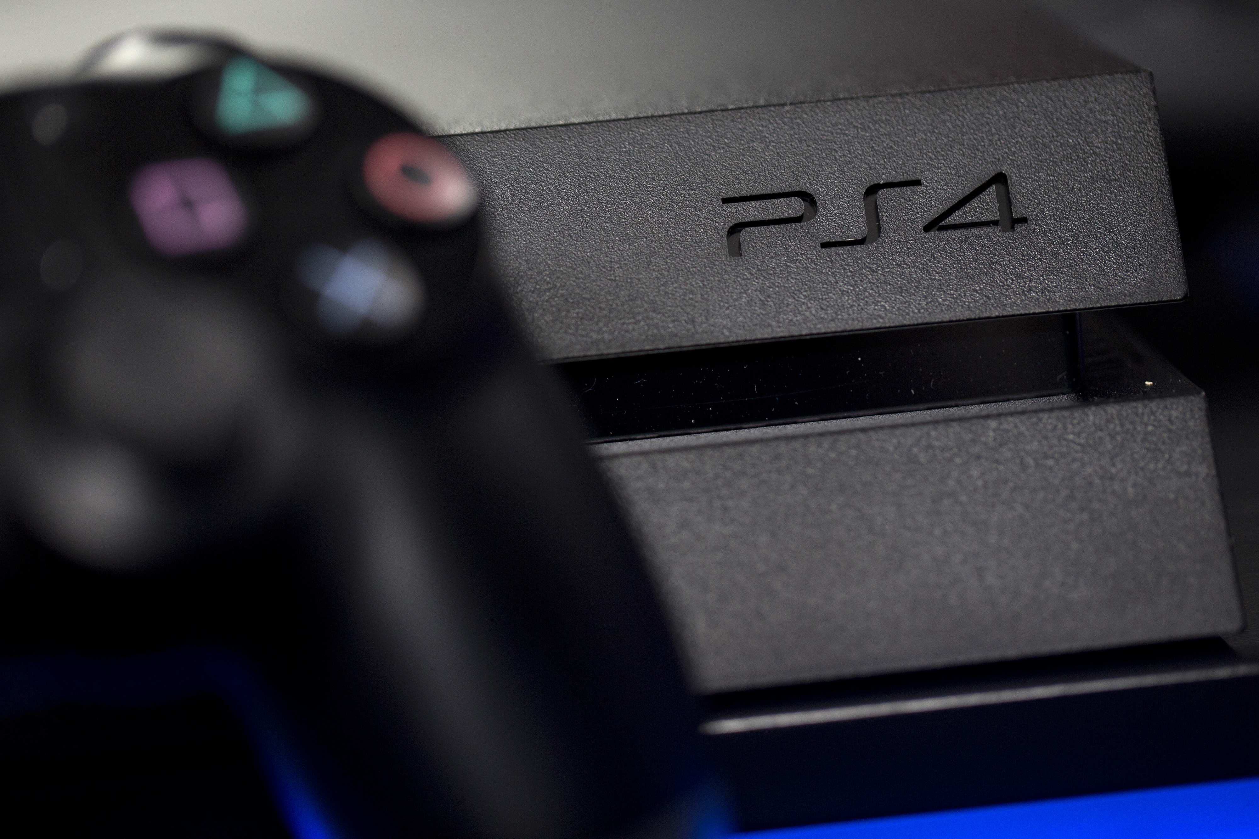 A logo sits on the front of a Sony PlayStation 4 (PS4) games console, manufactured by Sony Corp., in this arranged photograph taken in London, U.K., on Friday, Nov. 15, 2013. (Bloomberg—Getty Images)