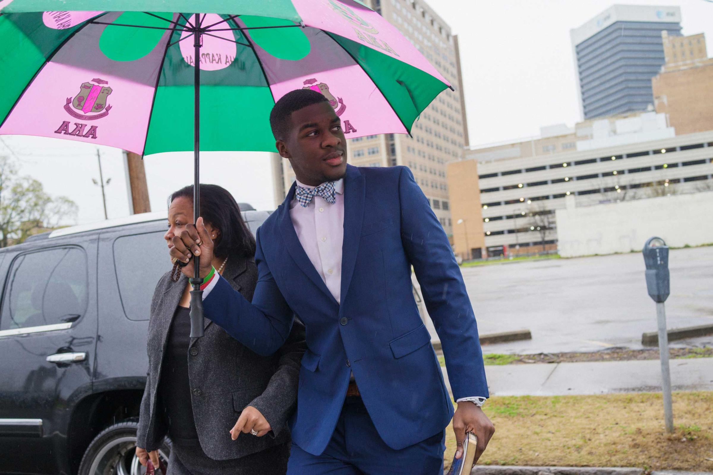 P.J. Garrett holds an umbrella for his mother, Dr. Cynthia Garrett, as they arrive at 16th Street Baptist Church in Birmingham, Ala. on March 22, 2015.