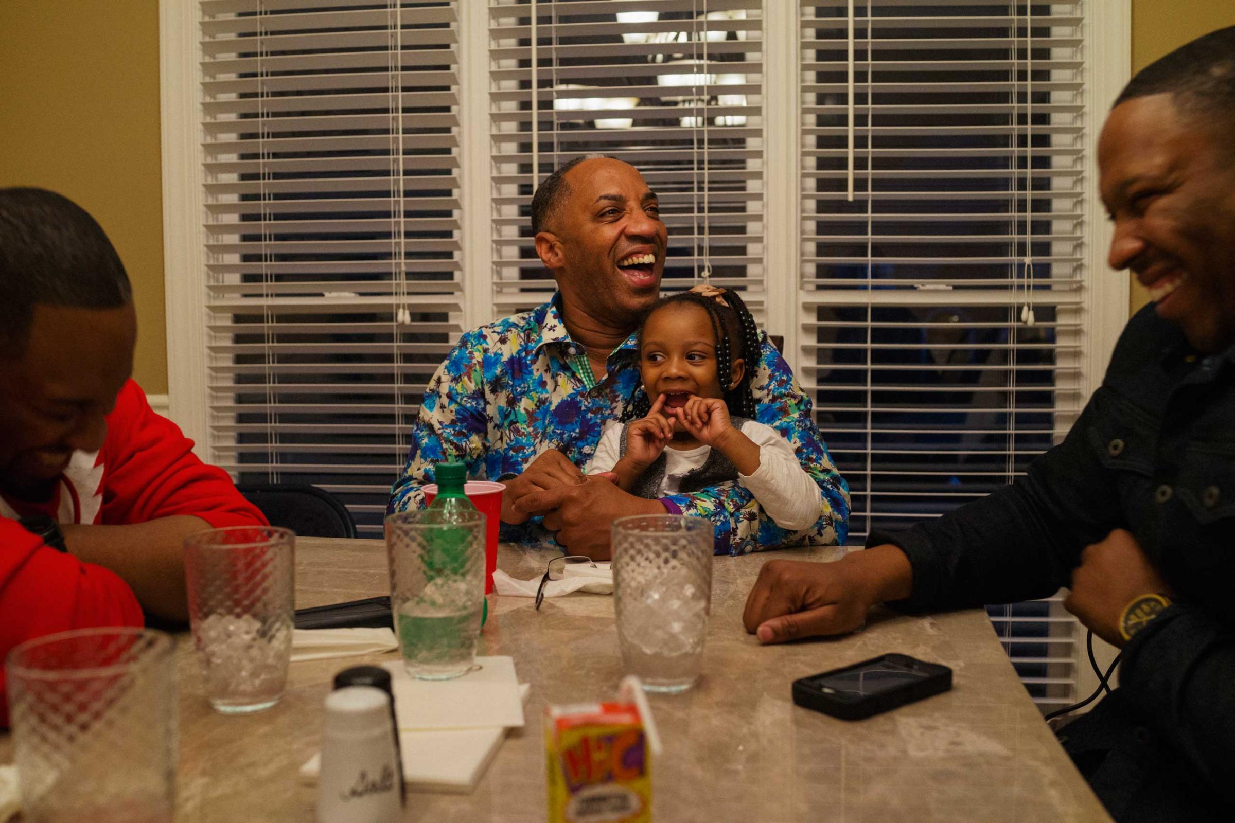 (L-R) Michael McClure Jr., Michael McClure Sr. and his granddaughter Brooklyn, and Darius McClure laugh during a lively family dinner at the home of Rev. Michael McClure Sr., in Birmingham, Ala. on March 22, 2015.