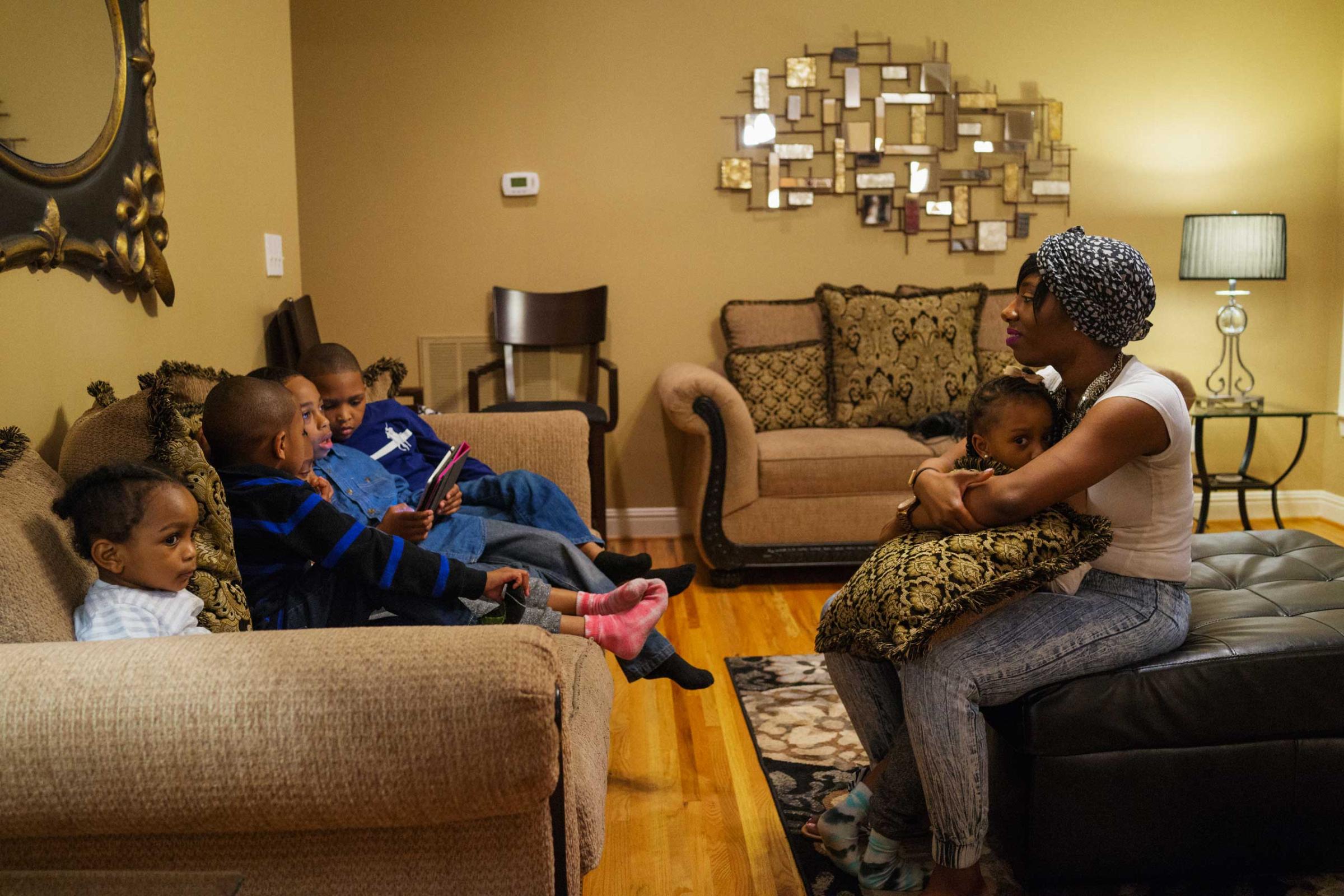 Angelique McClure hangs out with her nieces and nephews in the living room during a family dinner at her father's home in Birmingham, Ala. on March 22, 2015.