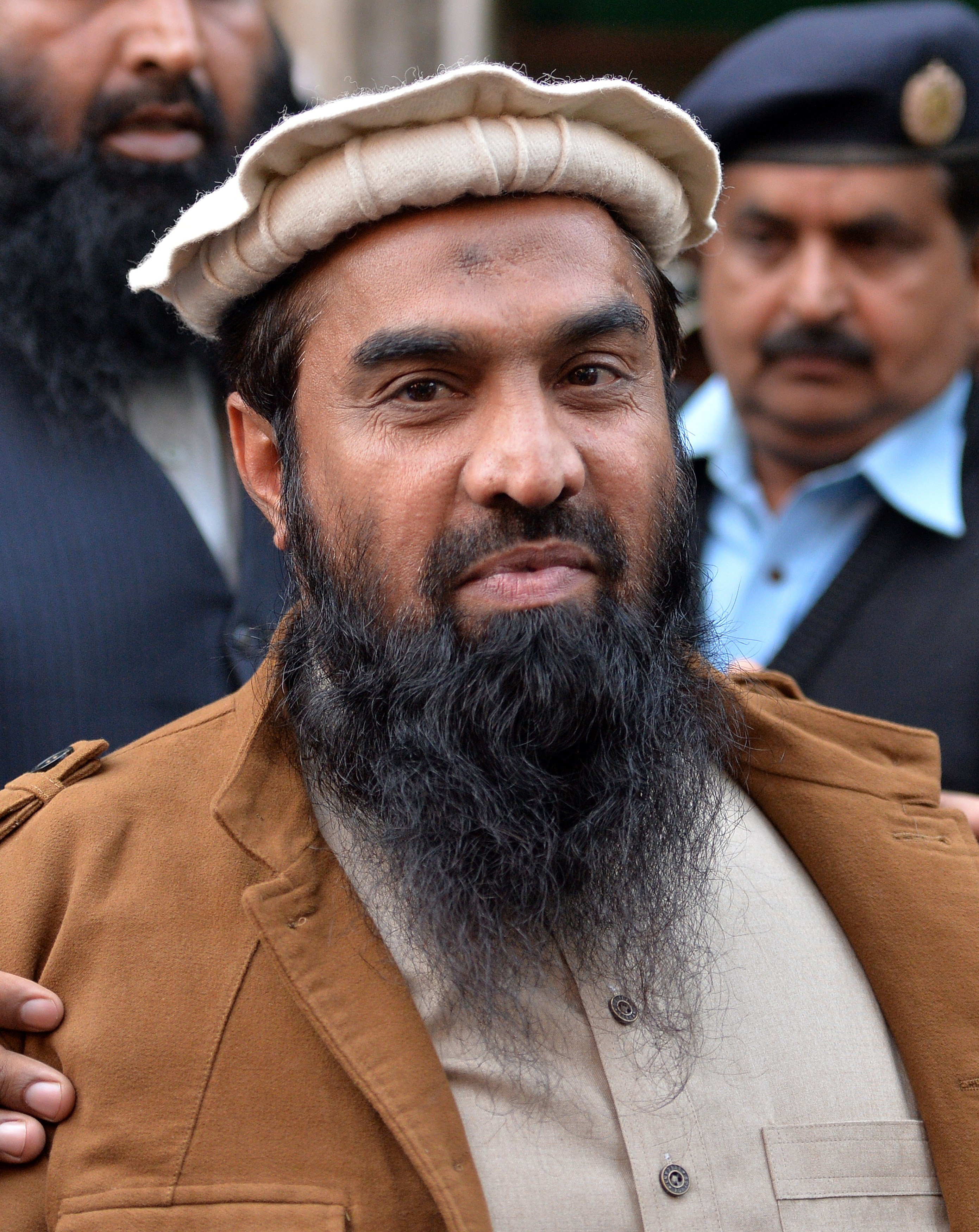 Pakistani security personnel escort Zaki-ur-Rehman Lakhvi, alleged mastermind of the 2008 Mumbai attacks, as he leaves the court after a hearing in Islamabad on Jan. 1, 2015 (Aamir Qureshi—AFP/Getty Images)