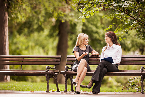 businesswomen-chatting-bench