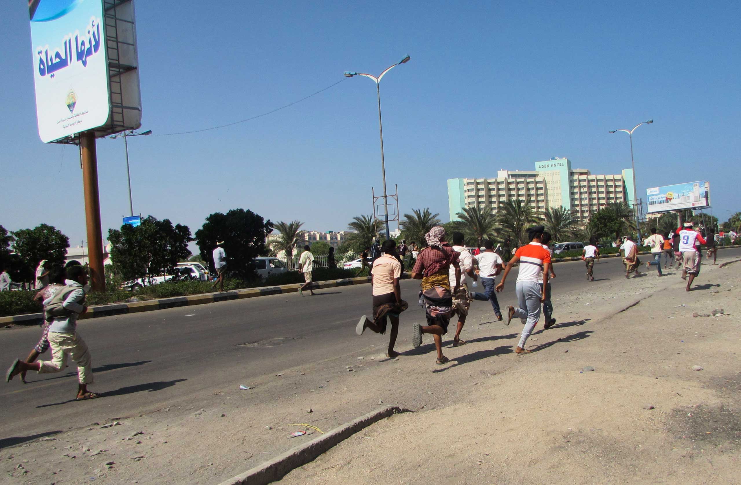 People flee after a gunfire on a street in the southern port city of Aden, Yemen, on March 25, 2015.