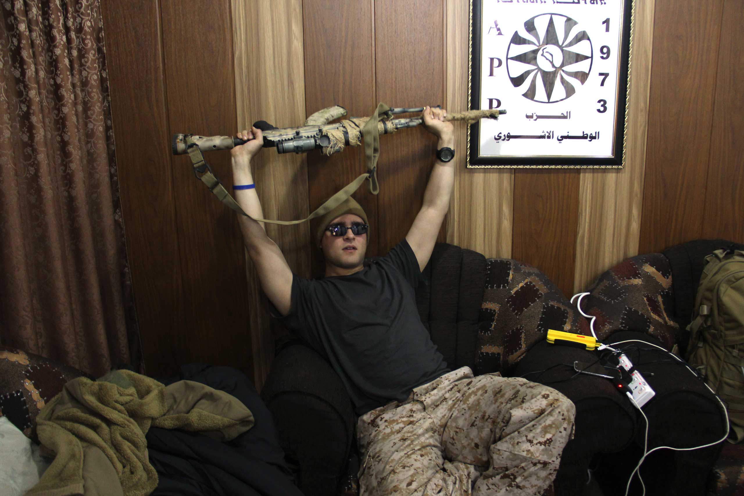 Louis in the living room where the foreign recruits sleep in Dwekh Nawsha headquarters in Dohuk, northern Iraq. (Rebecca Collard)