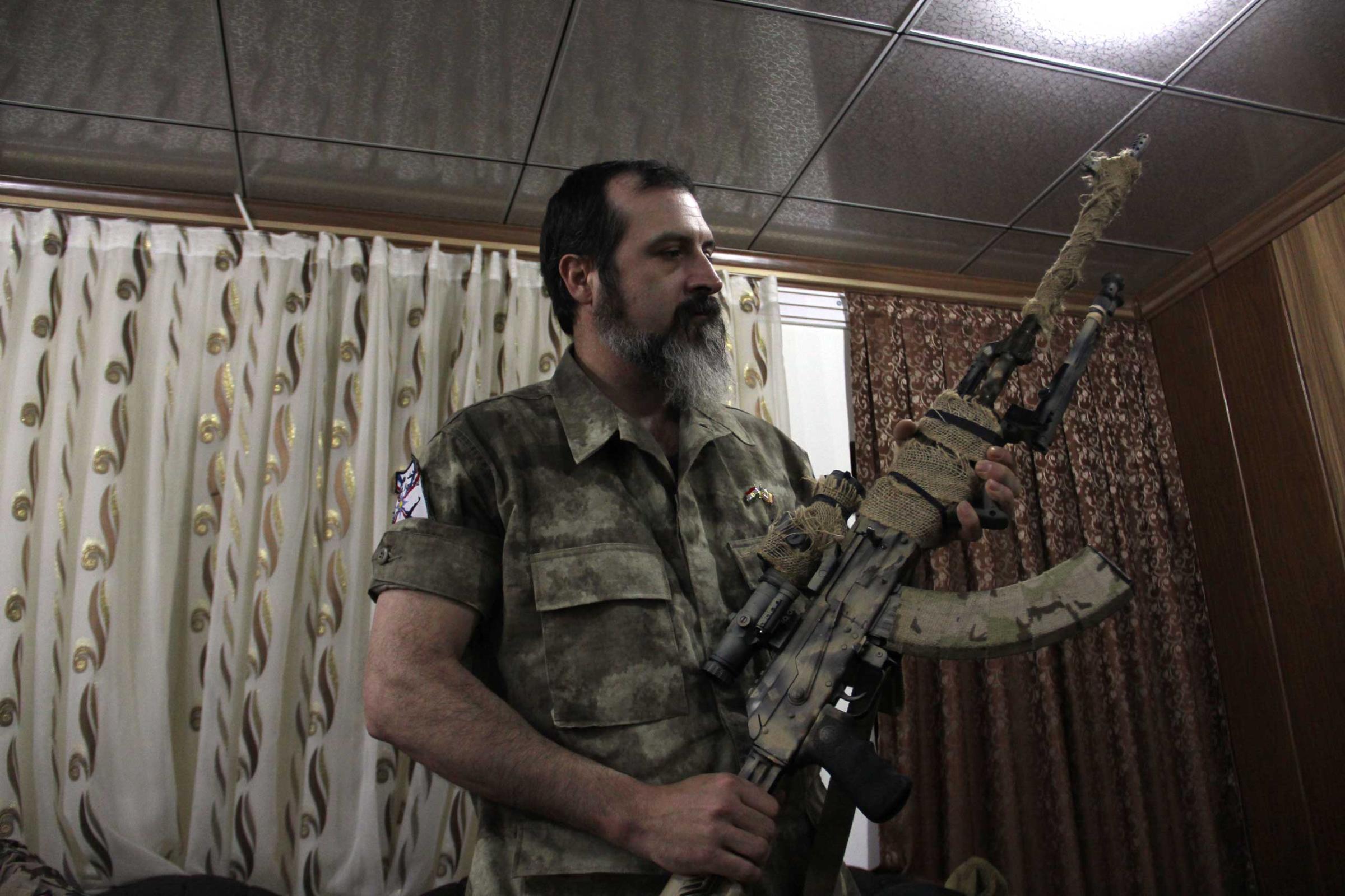 Scott holds his gun in the Dwekh Nawsha headquarters in Dohuk, northern Iraq.