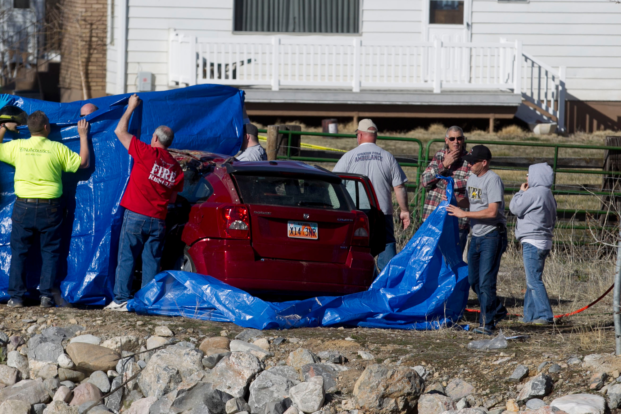 In this March 7, 2015 photo, officials respond to a report of a car crash in a river in Spanish Fork, Utah