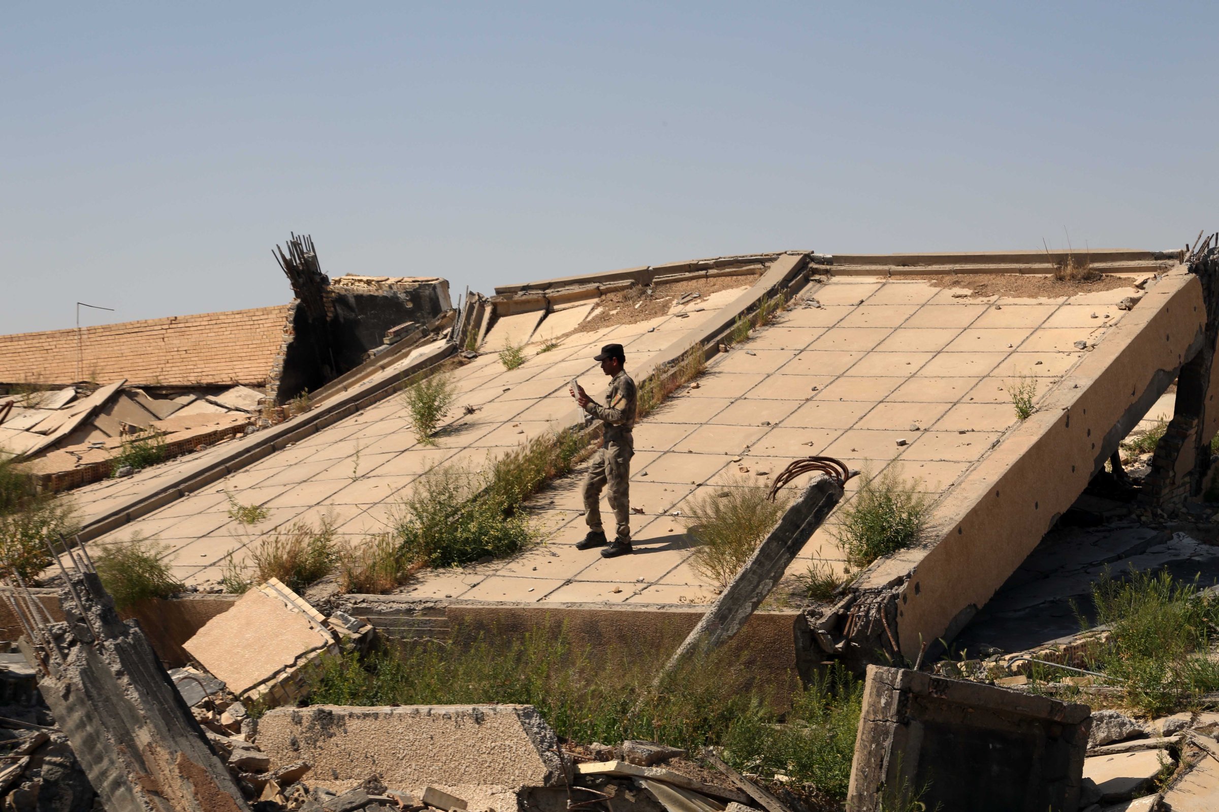 An Iraqi soldier takes photos of the demolished tomb of former Iraqi president, Saddam Hussein, in Tikrit, Iraq, March 15, 2015