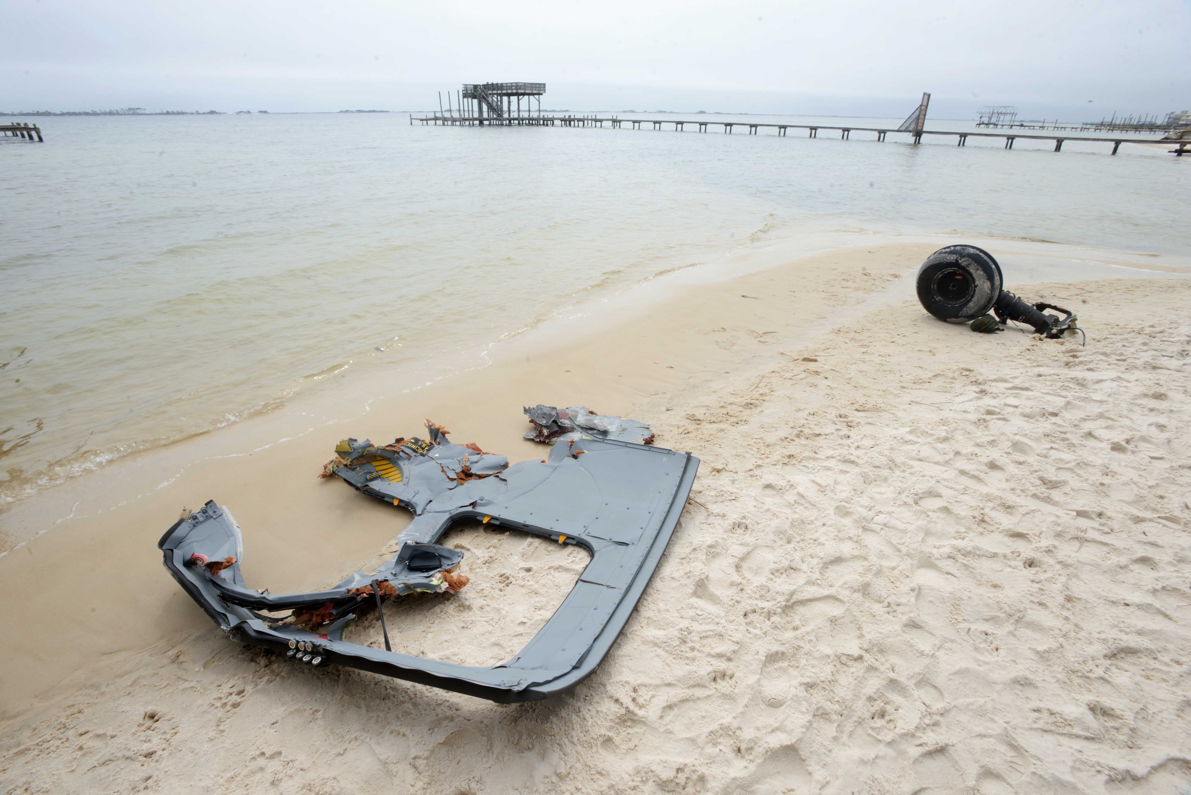 A wheel and pieces of fuselage from an Army Black Hawk helicopter sit along the shoreline of Santa Rosa Sound near Navarre, Fla. on Wednesday, March 11, 2015