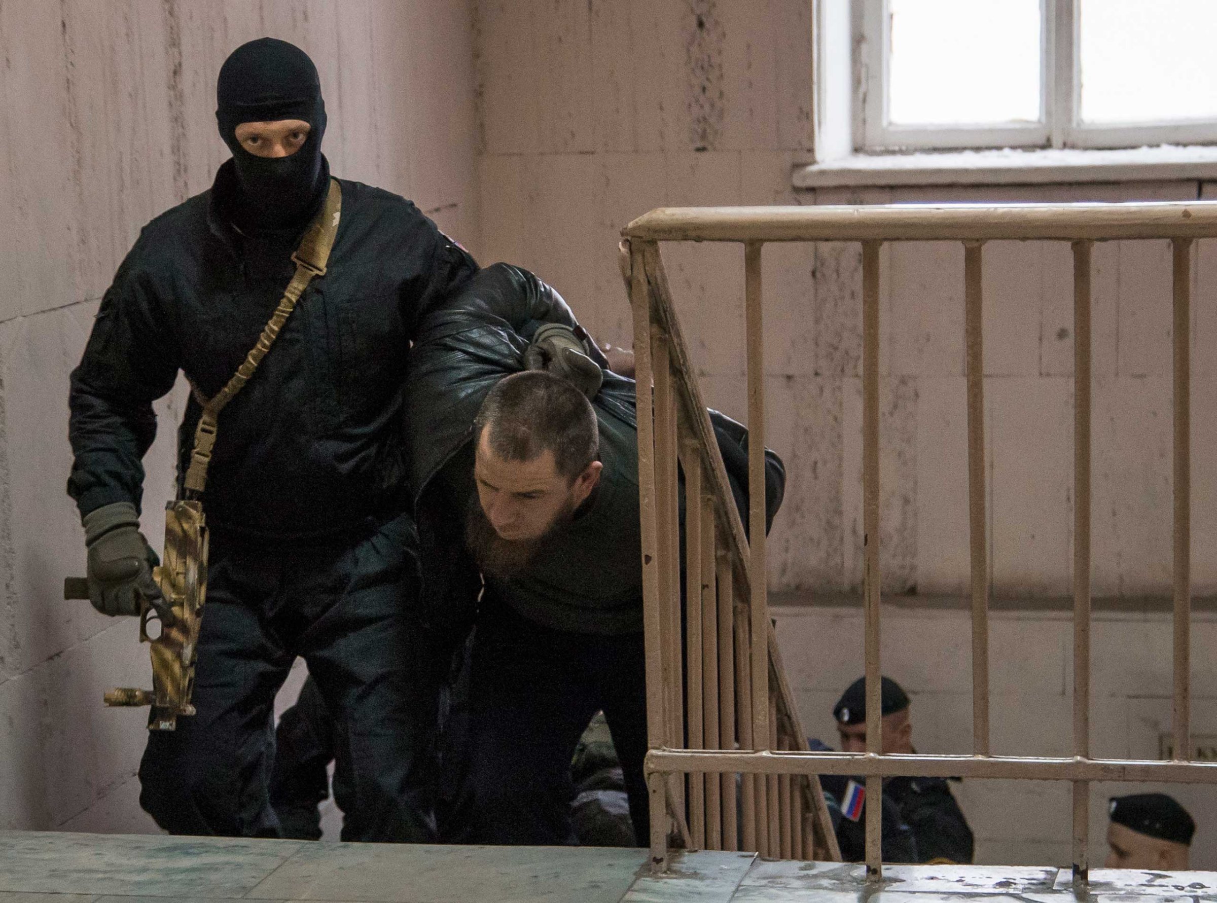 Police escort Tamerlan Eskerkhanov believed to be one of five suspects in the killing of Boris Nemtsov in a court room in Moscow, March 8, 2015.