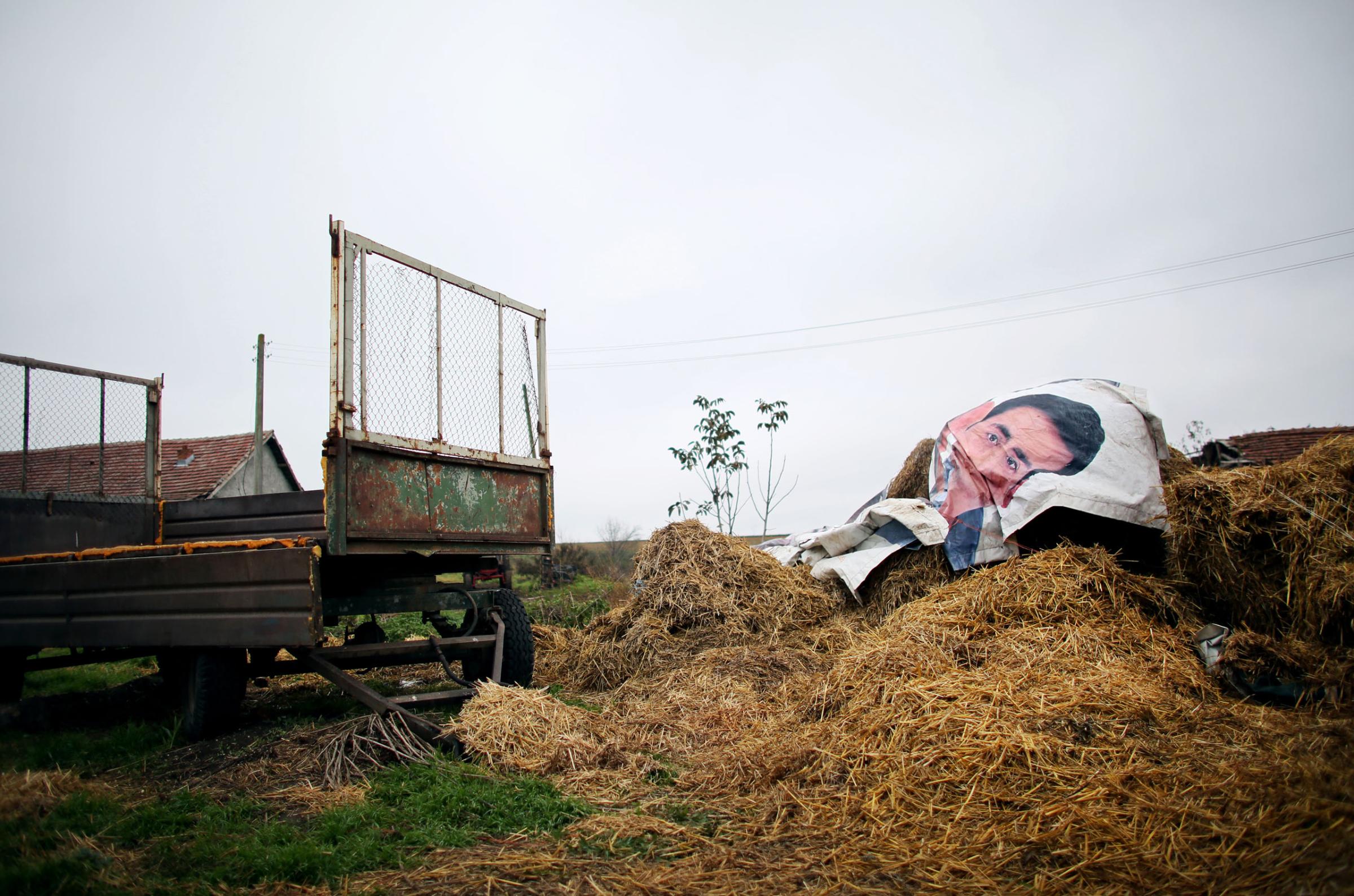An advertisement is used as covering for a farmer's stacks of hay, in Belene, on November 10th, 2014.This photo is from a project that aims to gauge the state and effect of democracy in the former Soviet satellite nation Bulgaria, two and a half decades after the fall of the Berlin Wall. The story of democracy in Bulgaria at age 25 is a cautionary tale about transplanting one-size-fits-all Western values to a nation still undergoing social and economic upheaval. Bulgaria is still one of the poorest, most corrupt nations in the European Union, its post-1989 hopes wilted by political instability, high crime rates and skyrocketing inflation. While Bulgarians can now freely vote and protest without much threat to their freedom, their new oppressor is corruption - which is at a 15 year high, across political and civil sectors alike. The ennui is so casually etched on the passerby's face that it becomes routine - one that fits in sadly well against a startling backdrop of rotting architecture, joblessness, and a vast population decline. Despite what democracy has changed in Bulgaria, the daily struggles of its populace remain largely untouched, trapped in a post-communist time capsule.This project was supported by a grant from The Pulitzer Center on Crisis Reporting. Photo by: Yana PaskovaCopyright © Yana Paskova 2014