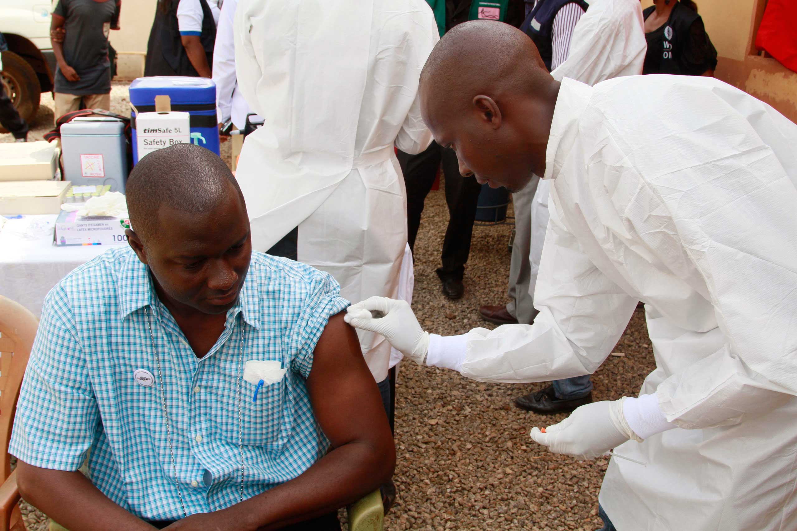 A health worker, right, cleans a man's arm before injecting him with a Ebola vaccine in Conakry, Guinea, March 7, 2015. (Youssouf Bah—AP)