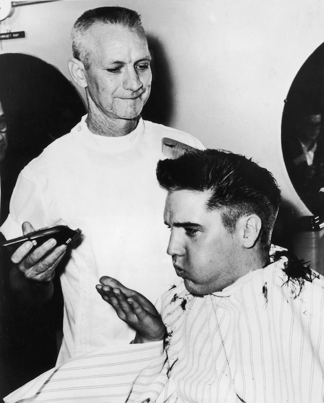 Elvis Presley receiving a haircut from a US Army barber at Fort Chaffee, Ark., in 1958 (Hulton Archive / Getty Images)
