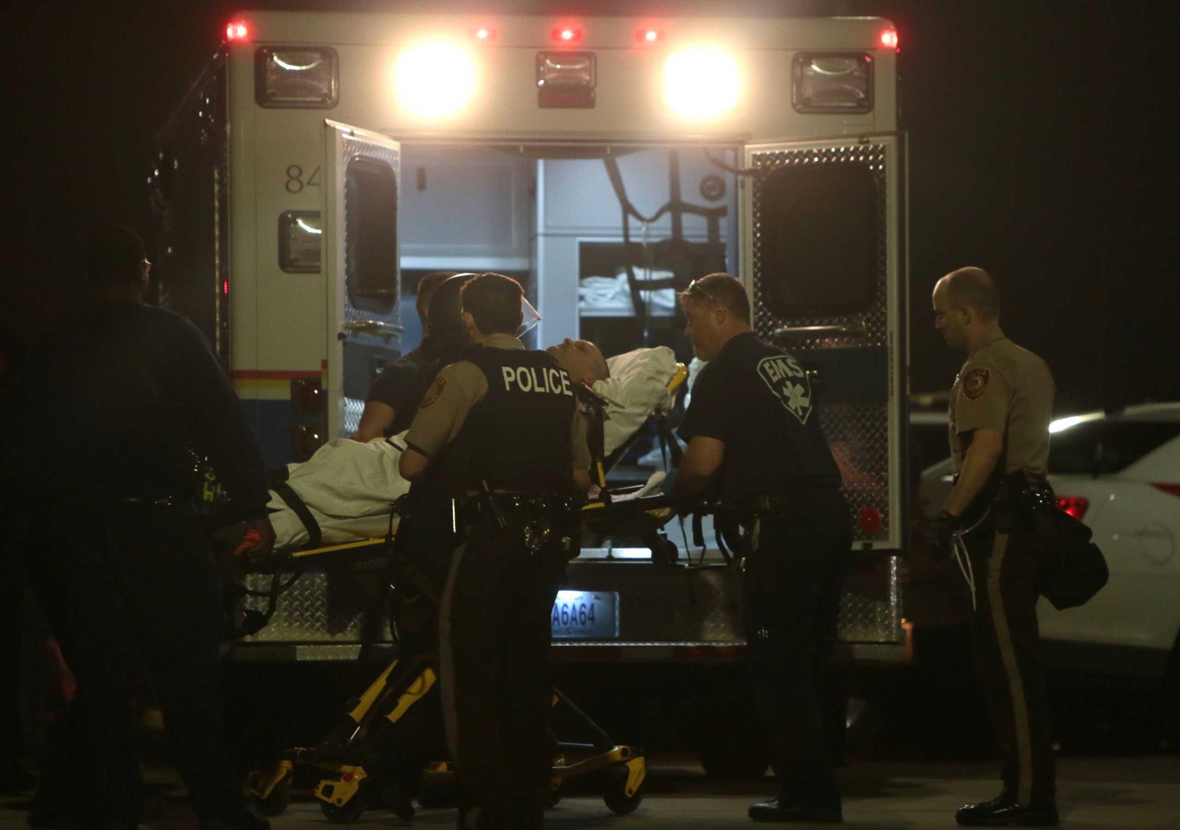 Paramedics load one of two police officer who were shot while standing guard in front of the Ferguson Police Station during a protest on March 12, 2015.