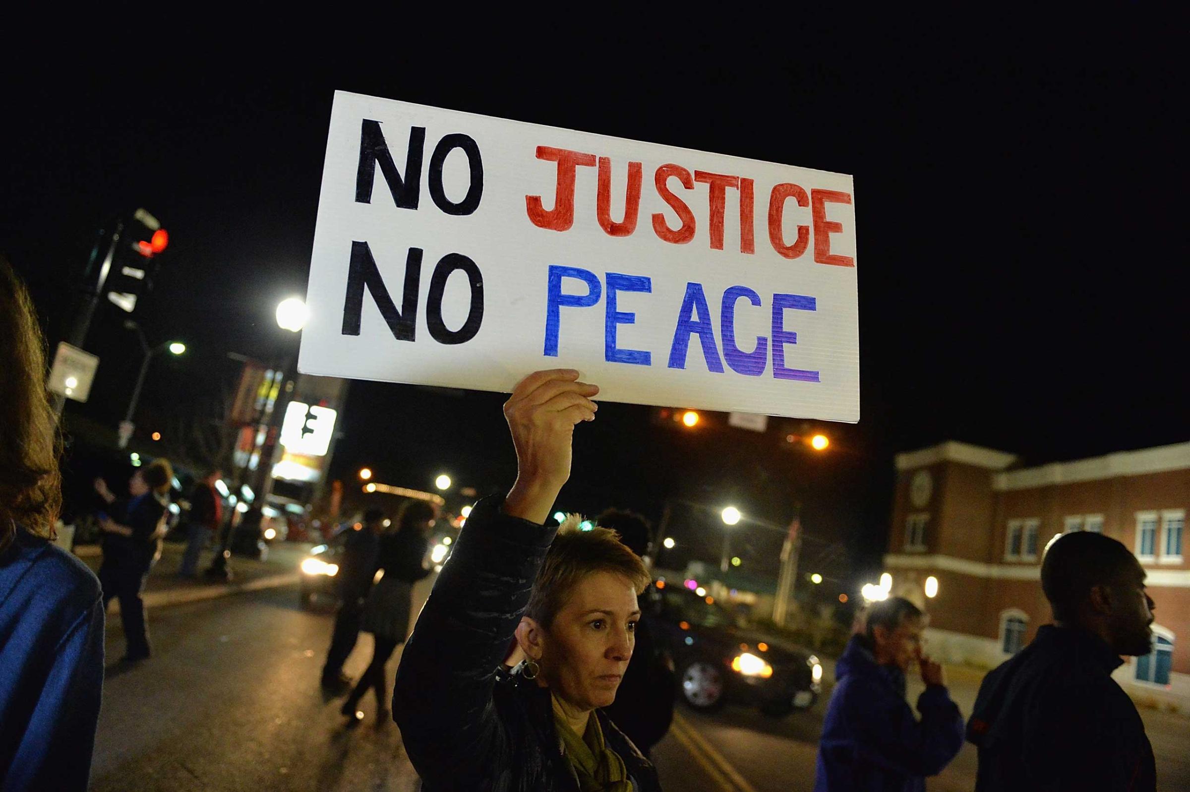 Protestors hold signs during a protest outside the Ferguson Police Department on March11, 2015 in Ferguson.