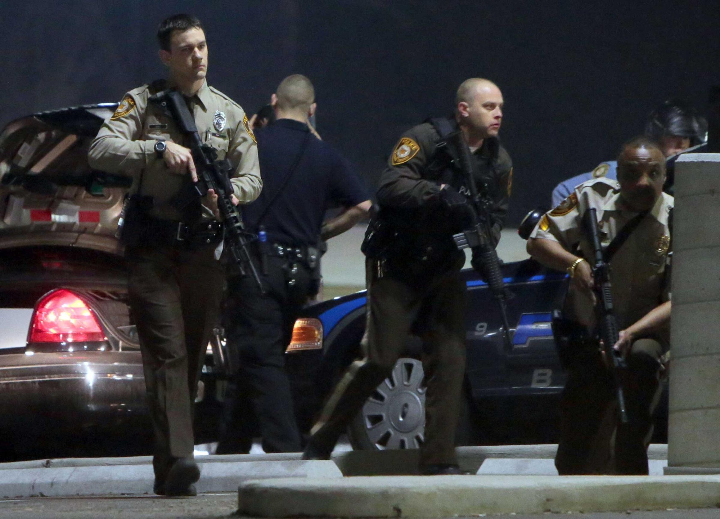 Police mobilize in the parking lot of the Ferguson Police Station after two police officers were shot while standing guard in front of the Ferguson Police Station, March 12, 2015.