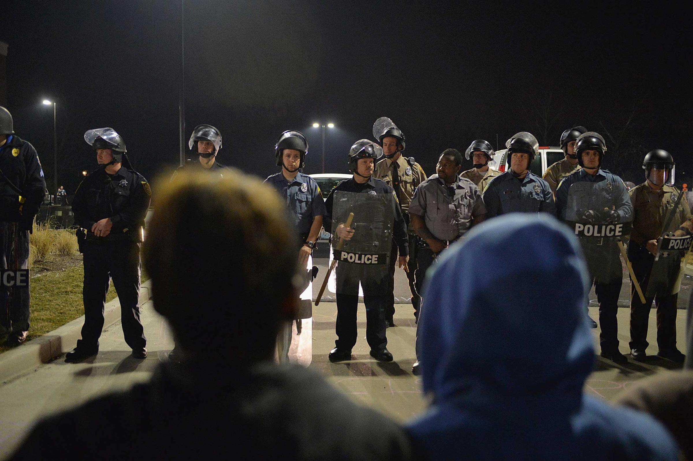 Police officers stand on alert during a protests outside the Ferguson Police Department on March 11, 2015 in Ferguson, Mo.