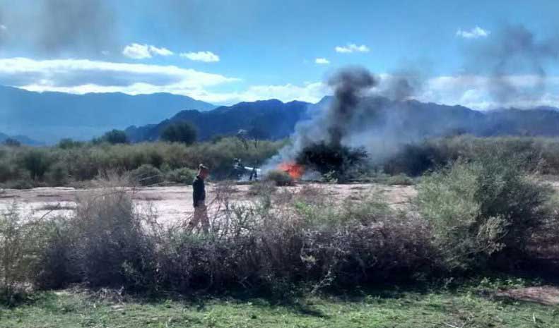 A man stands near the smoking remains of a helicopter that crashed with another near Villa Castelli in the La Rioja province of Argentina, March 9, 2015.