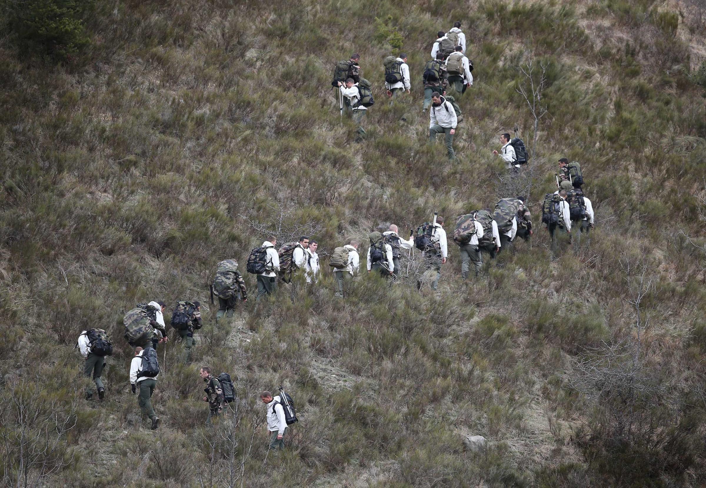 French military personnel walk up the mountainside near Seyne, France on March 25, 2015.