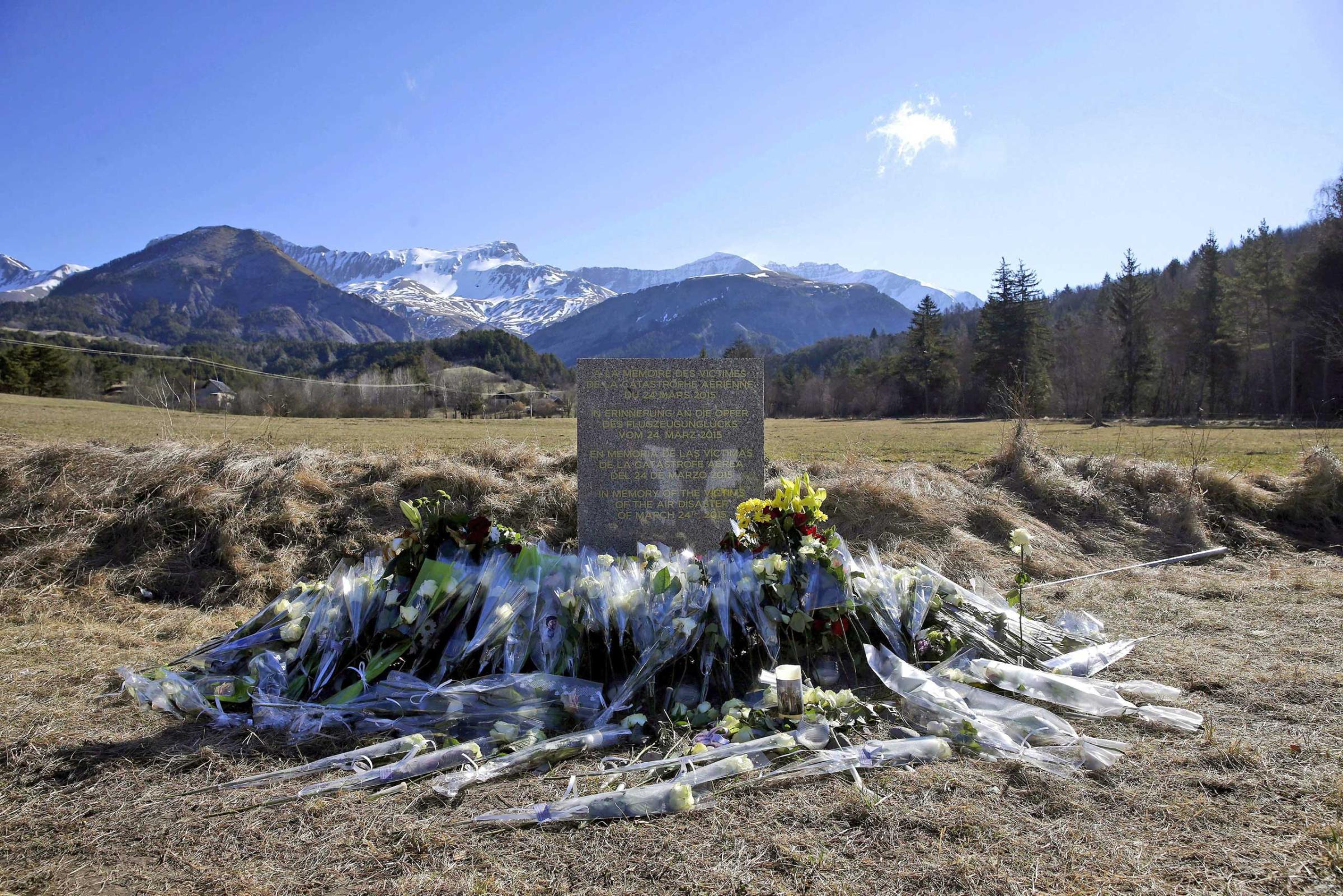 Flowers are left in front of the monument in homage to the victims of Germanwings Flight 4U 9525 in Le Vernet, southeastern France, March 27, 2015.