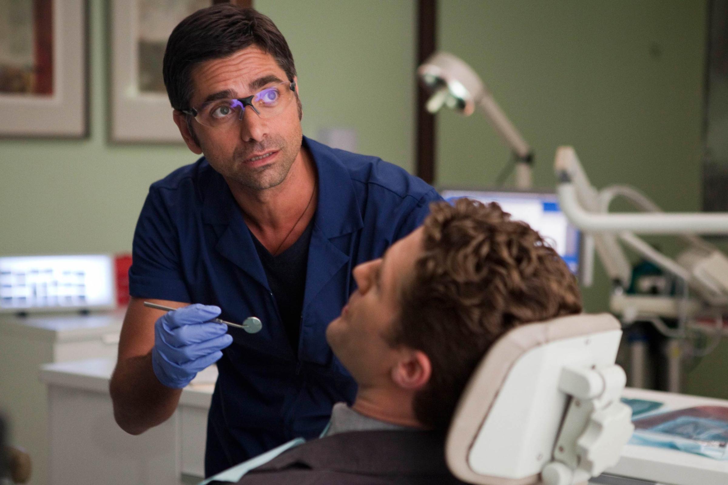 GLEE: Dr. Carl (guest star John Stamos, L) checks out Will's (Matthew Morrison, R) dental hygiene in the "Britney/Brittany" episode of GLEE airing Tuesay, Sept. 28 (8:00-9:00 PM ET/PT) on FOX. ©2010 Fox Broadcasting Co. CR: Adam Rose/FOX