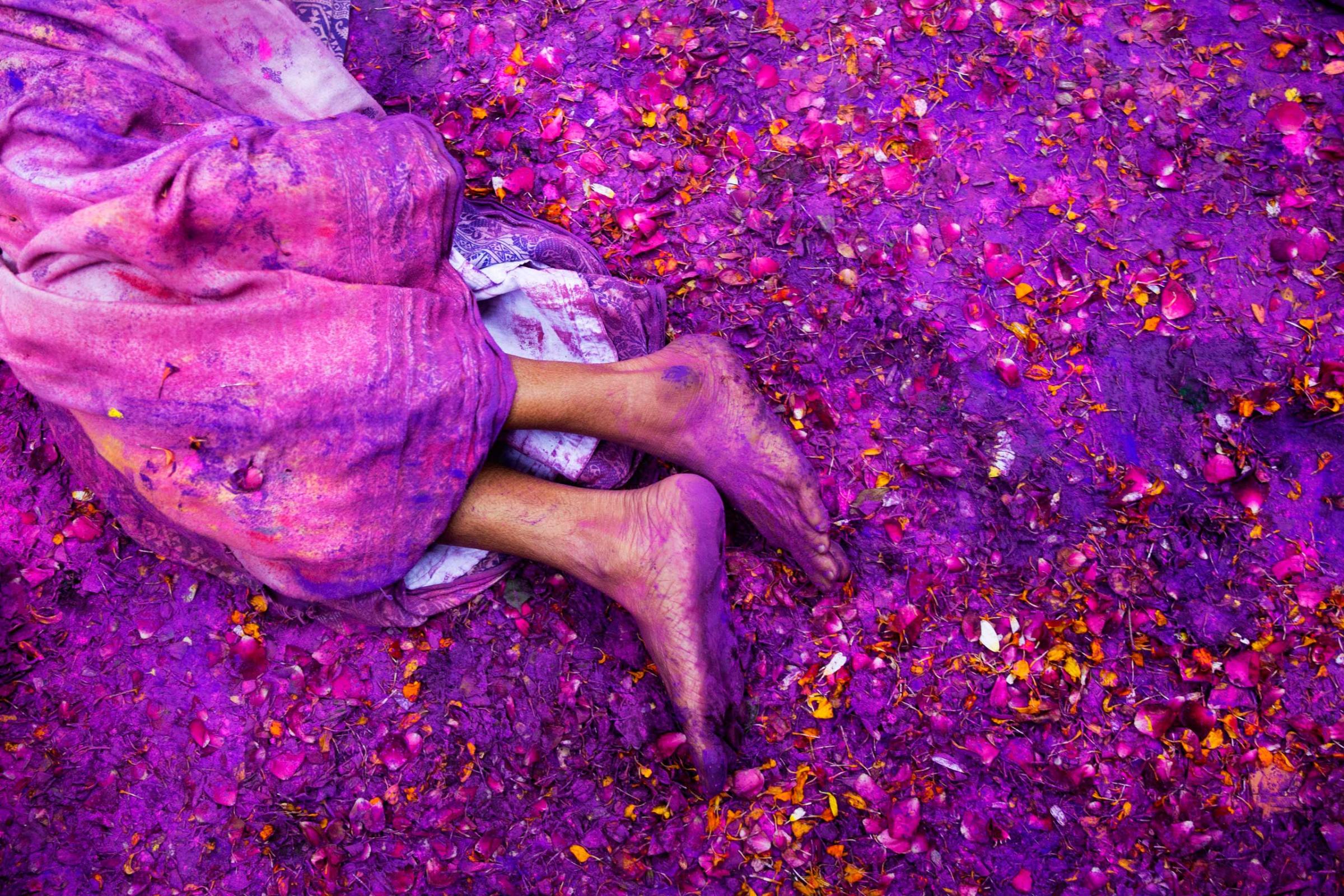 A Hindu widow lies on a sludgy ground filled with a mixture of colored powder, water and flower petals during celebrations to mark Holi, the Hindu festival of colors, at the Meera Sahabhagini Widow Ashram in Vrindavan, India, March 3, 2015.