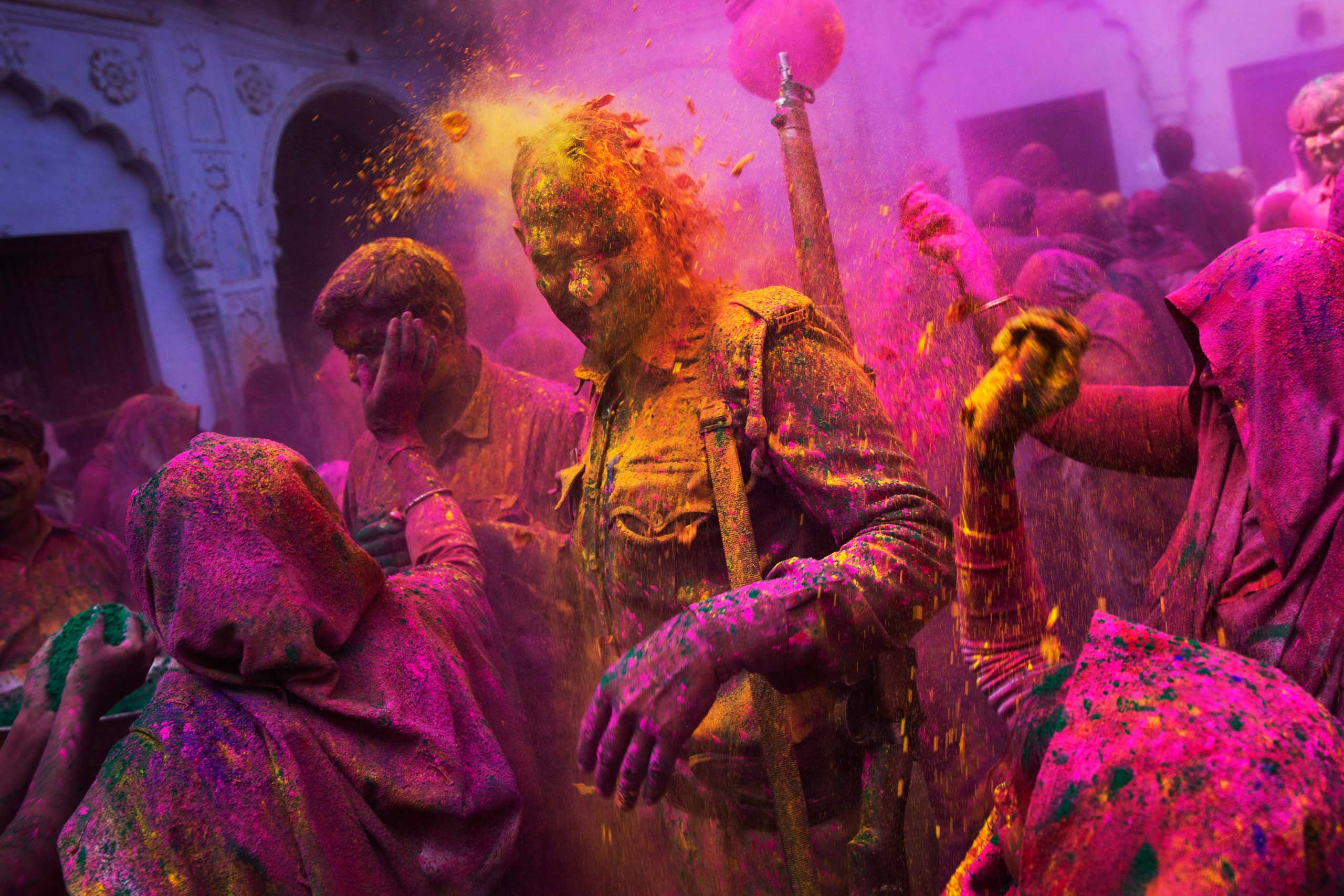 Hindu widows throw colored powder on an Indian policeman as they celebrate Holi, the Hindu festival of colors, at the Meera Sahabhagini Widow Ashram in Vrindavan, India, March 3, 2015.