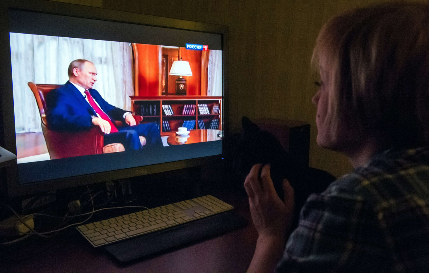 A woman looks at Russian President Vladimir Putin speaking as she watches an internet broadcast of the documentary Homeward Bound, on March 15, 2015 in Moscow. (Dmitry Serebryakov —AFP/Getty Images)