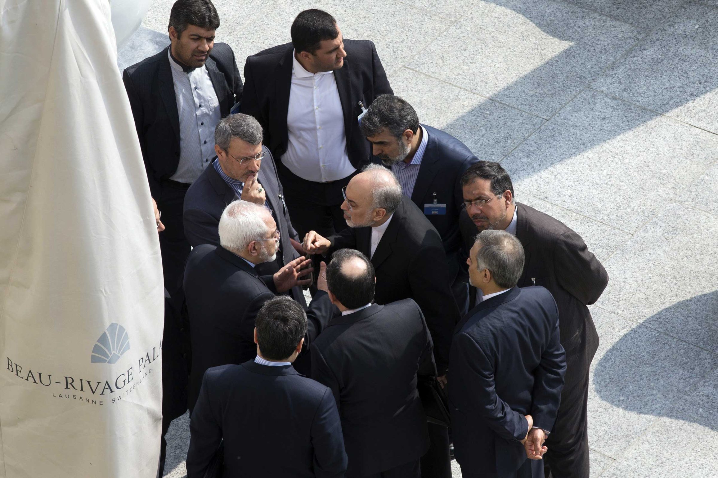 Iran's Foreign Minister Mohammad Javad Zarif, center, and head of the Atomic Energy Organization of Iran Ali Akbar Salehi, center right, talk outside with aides after a morning negotiation session with U.S. Secretary of State John Kerry over Iran's nuclear programme in Lausanne, Switzerland, March 19, 2015.