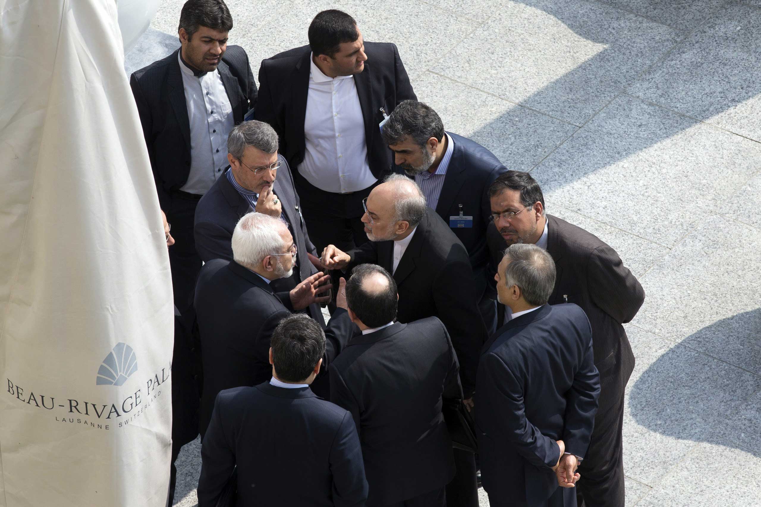 Iranian Foreign Minister Mohammad Javad Zarif, and the head of the Atomic Energy Organization of Iran, Ali Akbar Salehi, talk with aides after a morning negotiation session with U.S. Secretary of State John Kerry over Iran's nuclear program in Lausanne, Switzerland, on March 19, 2015 (Brian Snyder—AFP/Getty Images)
