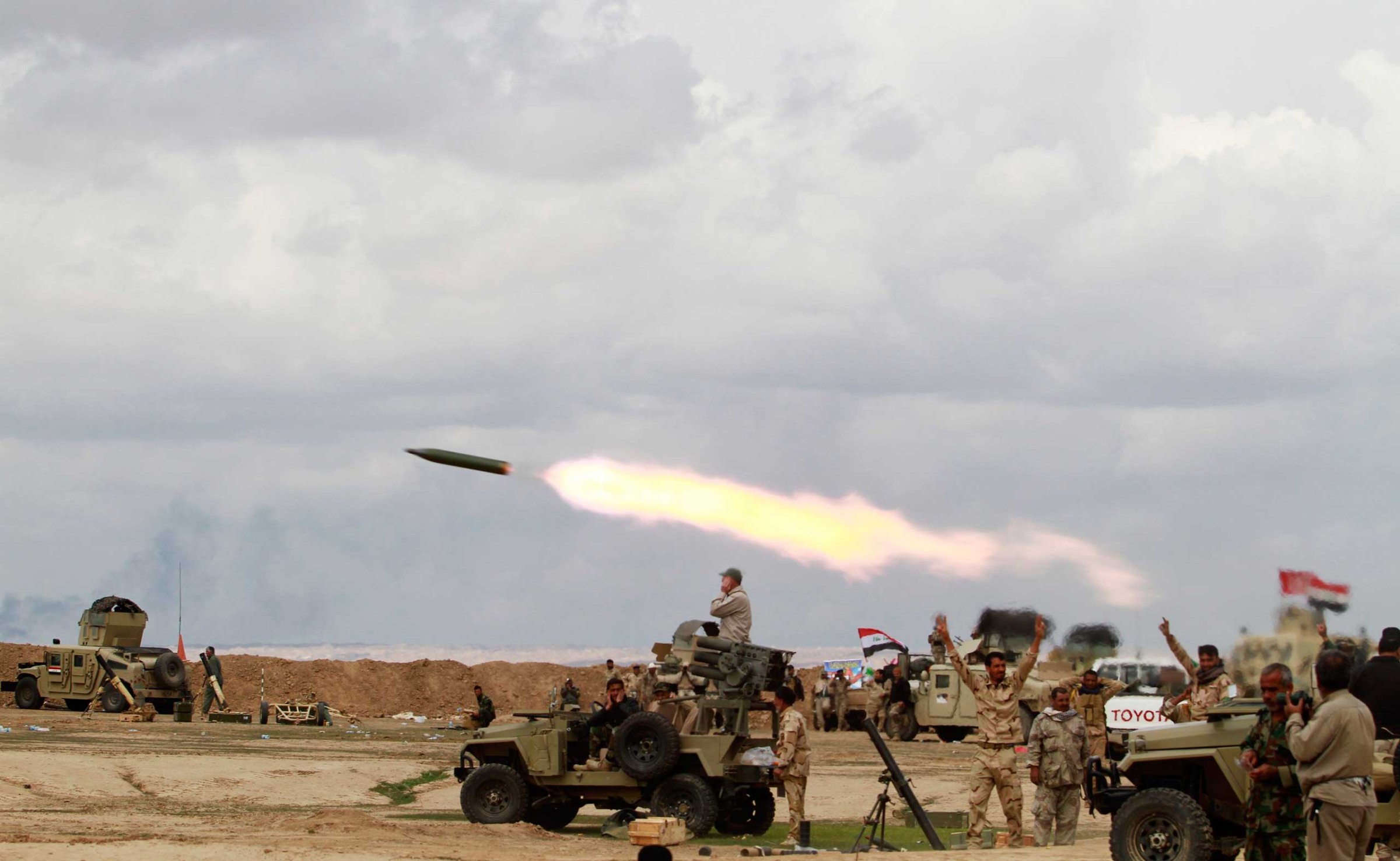 Shi’ite fighters launch a rocket towards ISIS militants during heavy fighting in Salahuddin province, Iraq, March 4, 2015.