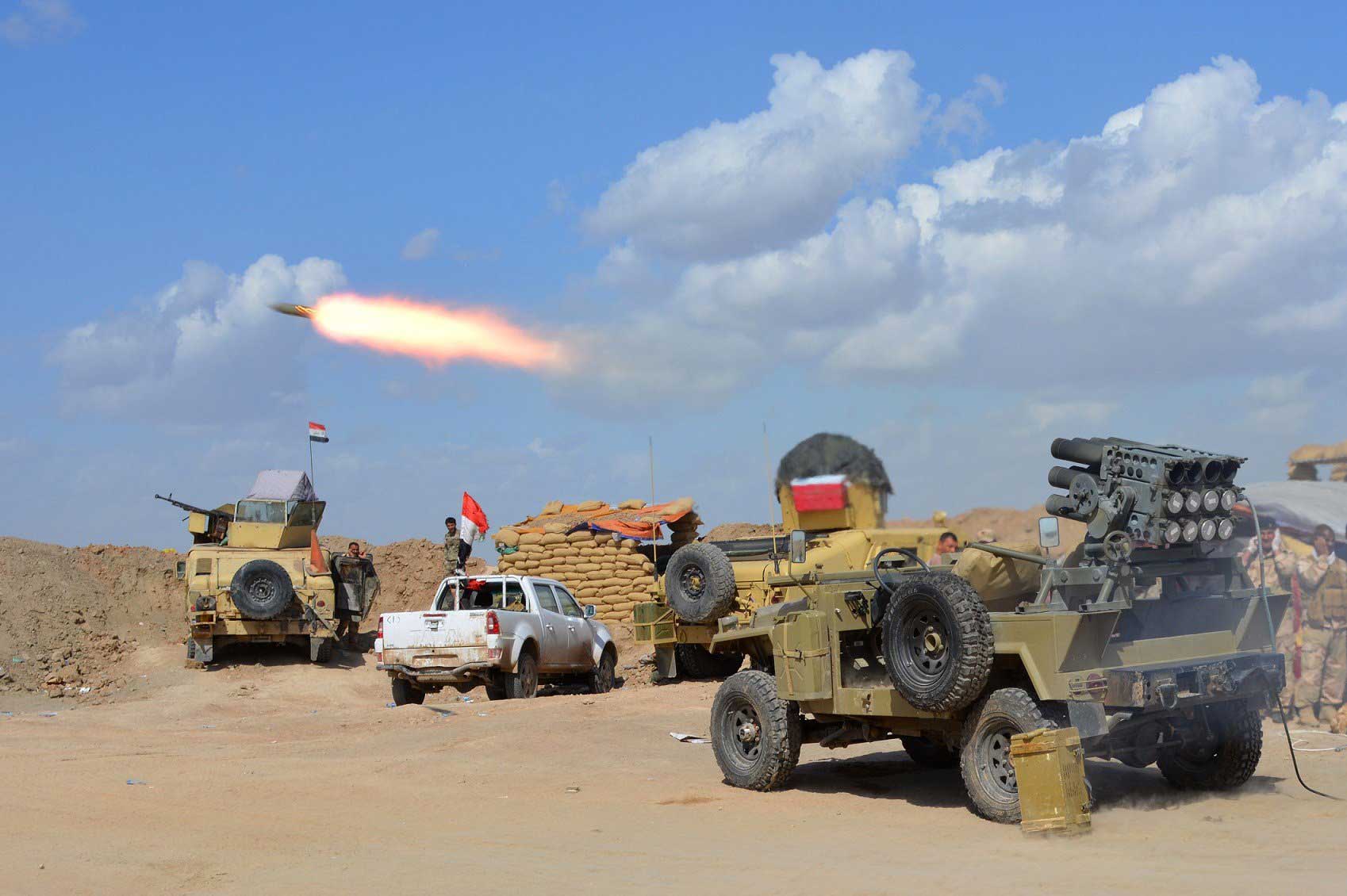 Iraqi government forces and allied militias fire weaponry from a position in the northern part of Diyala province, bordering Salaheddin province, as they take part in an assault to retake the city of Tikrit from ISIS militants, March 2, 2015. (Younis Al-Bayati—AFP/Getty Images)