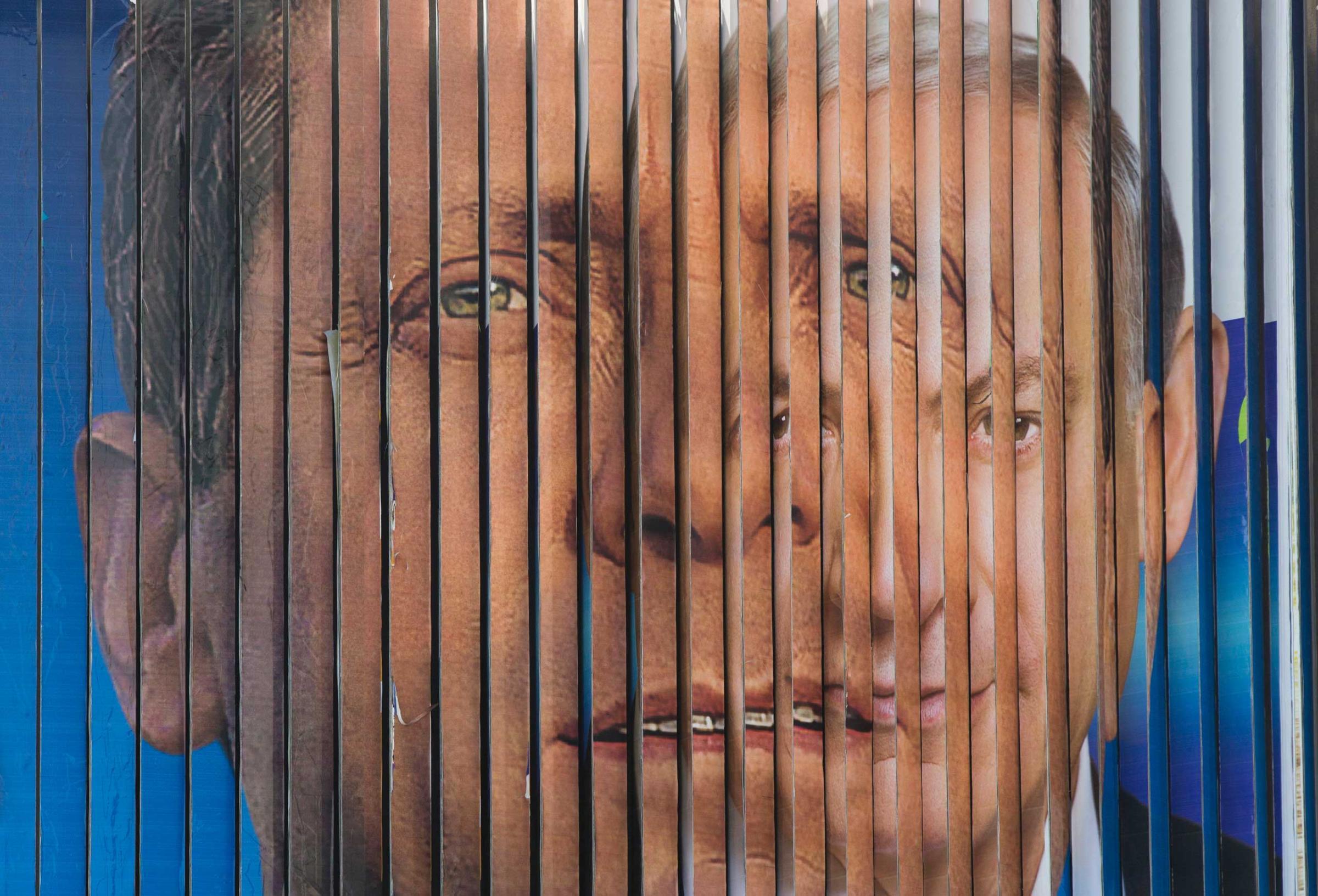 An election campaign billboard shifts between images of Israel's Labor Party leader Isaac Herzog, left, and Likud Party leader and Israel's Prime Minister Benjamin Netanyahu in Tel Aviv, March 15, 2015.