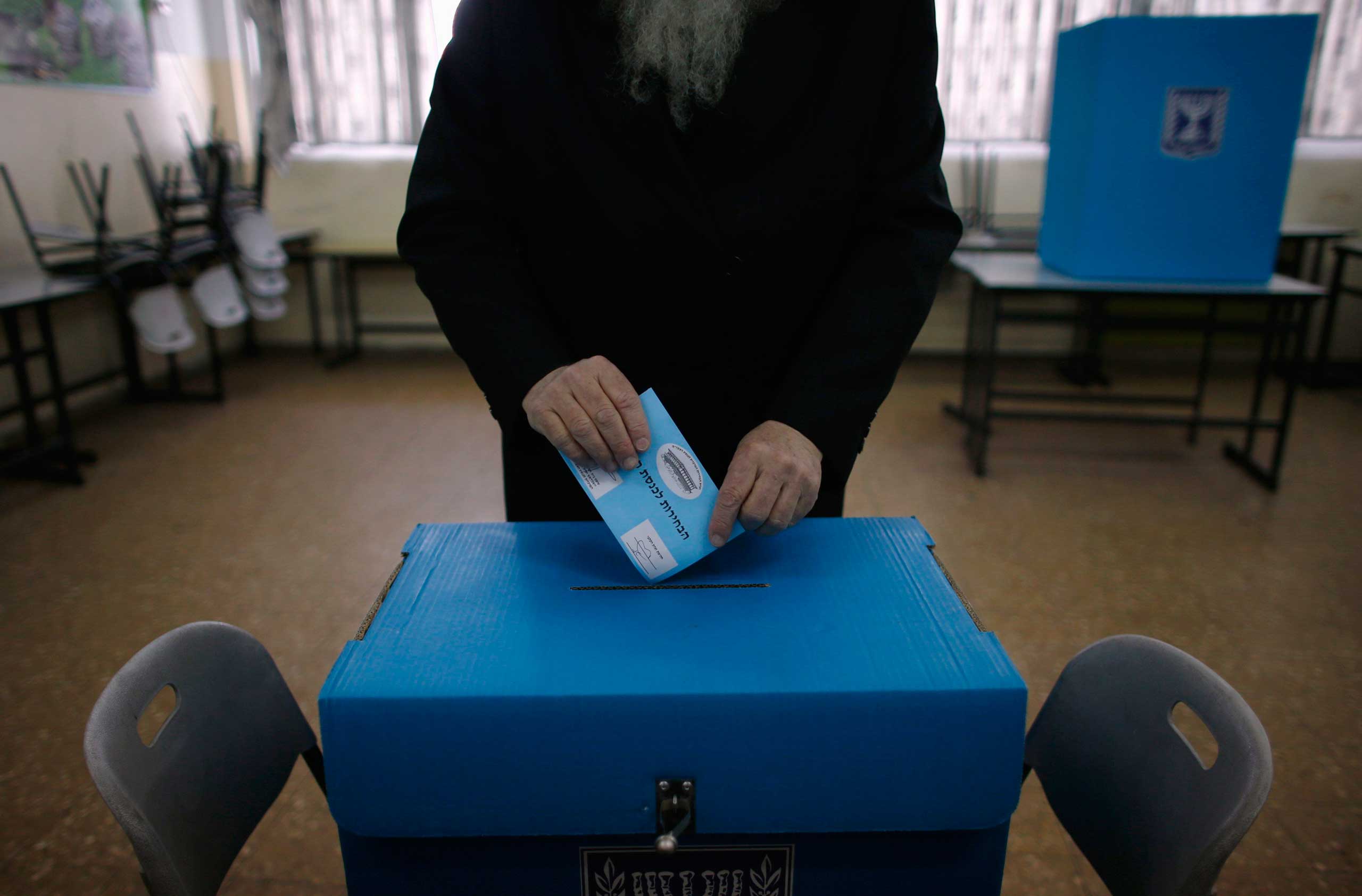 A ultra-Orthodox Jewish man casts his ballot for the parliamentary election at a polling station in Jerusalem March 17, 2015.